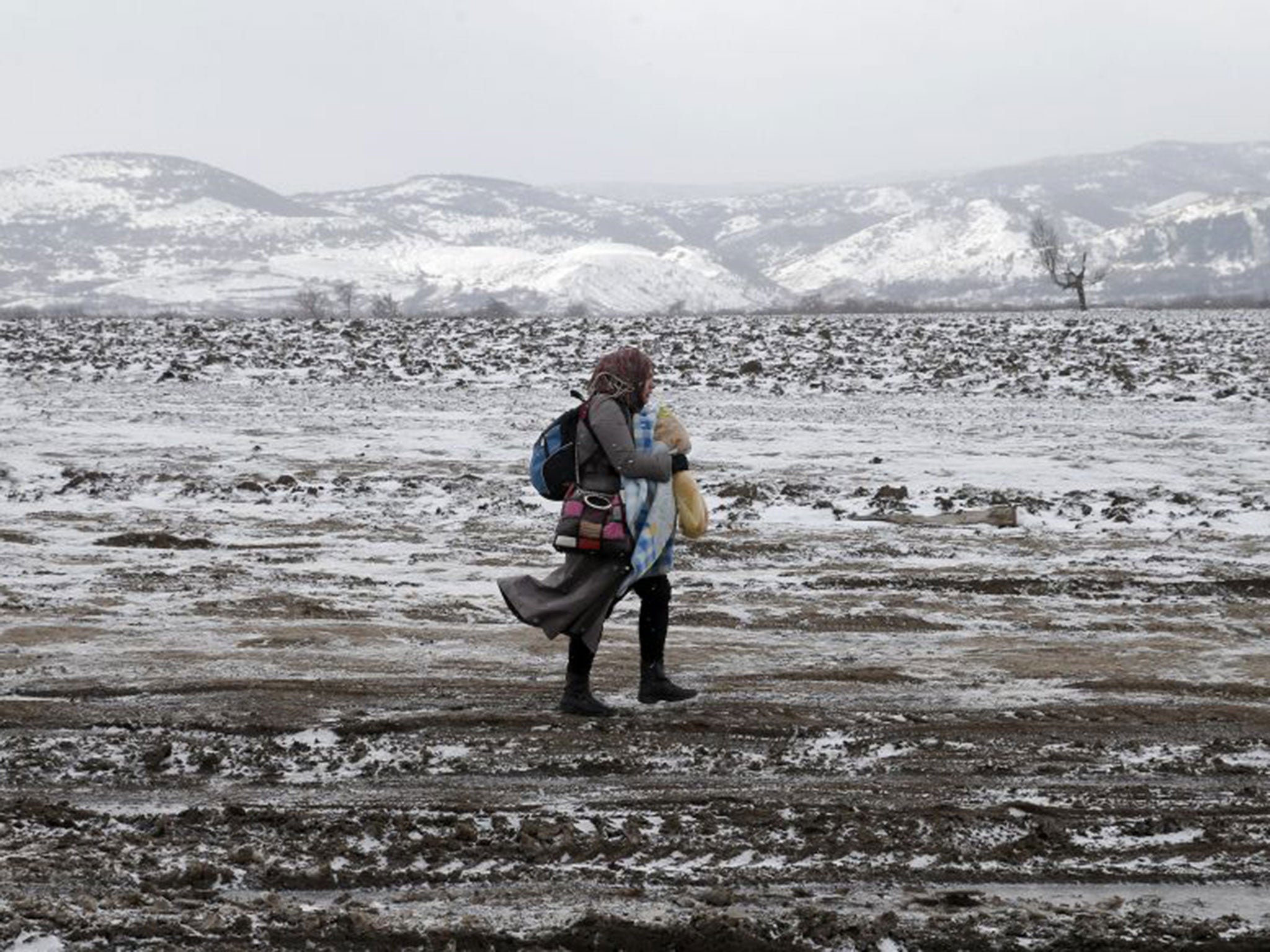 A refugee mother and her child brave temperatures as low as minus 20C after crossing into Serbia from Macedonia