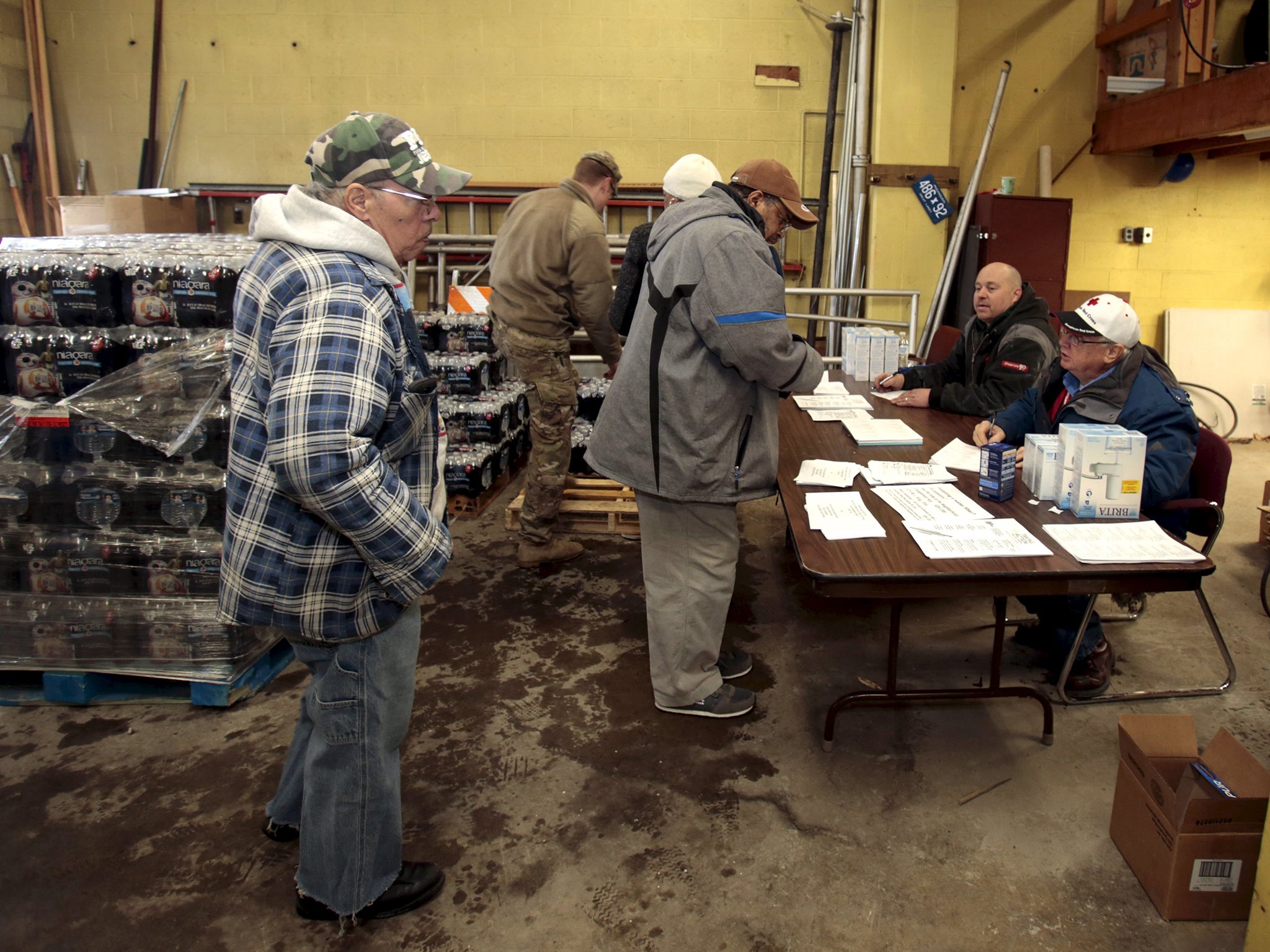 Flint residents pick up bottled water and water filters at a fire station in Flint. Michigan National Guard members were set to arrive in Flint to join door-to-door efforts to distribute bottled water and other supplies to residents coping with the city's crisis over lead-contaminated drinking water