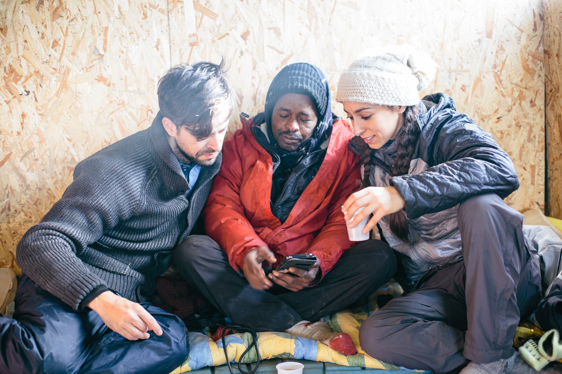 Jolyan and Oona sit with Dr Mohammed Adam Eisaballa, a refugee living in the Jungle