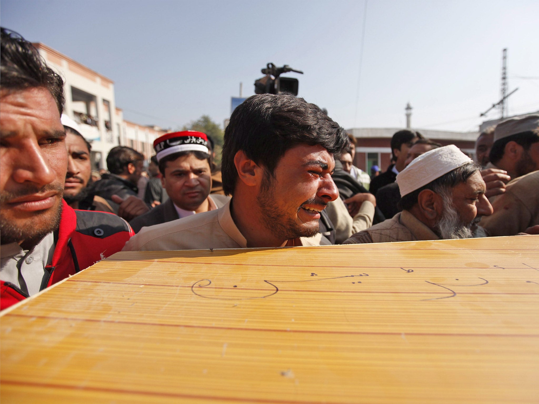 People move the body of a victim outside a hospital in Charsadda, Pakistan
