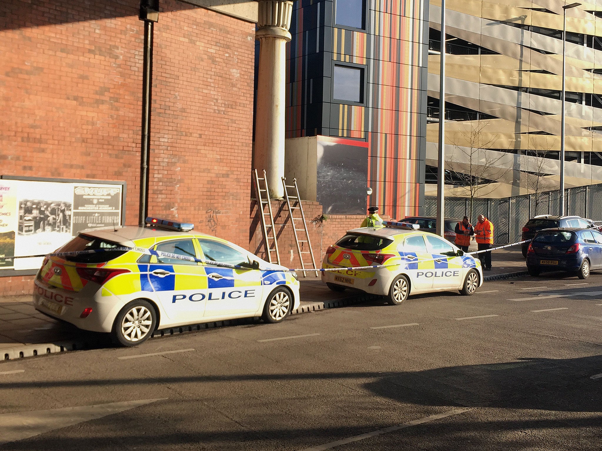 Police close to the scene in Salford, Greater Manchester, after a man's body was discovered next to a burning tent