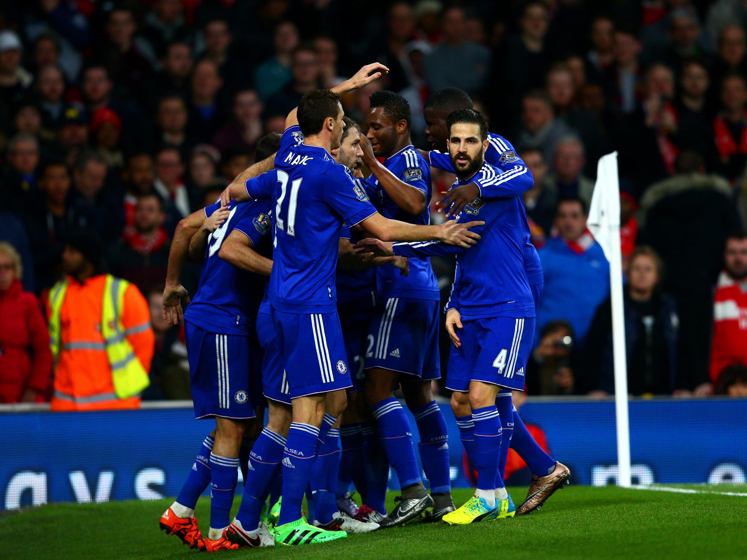 Costa is mobbed by his Chelsea team-mates after scoring the opener