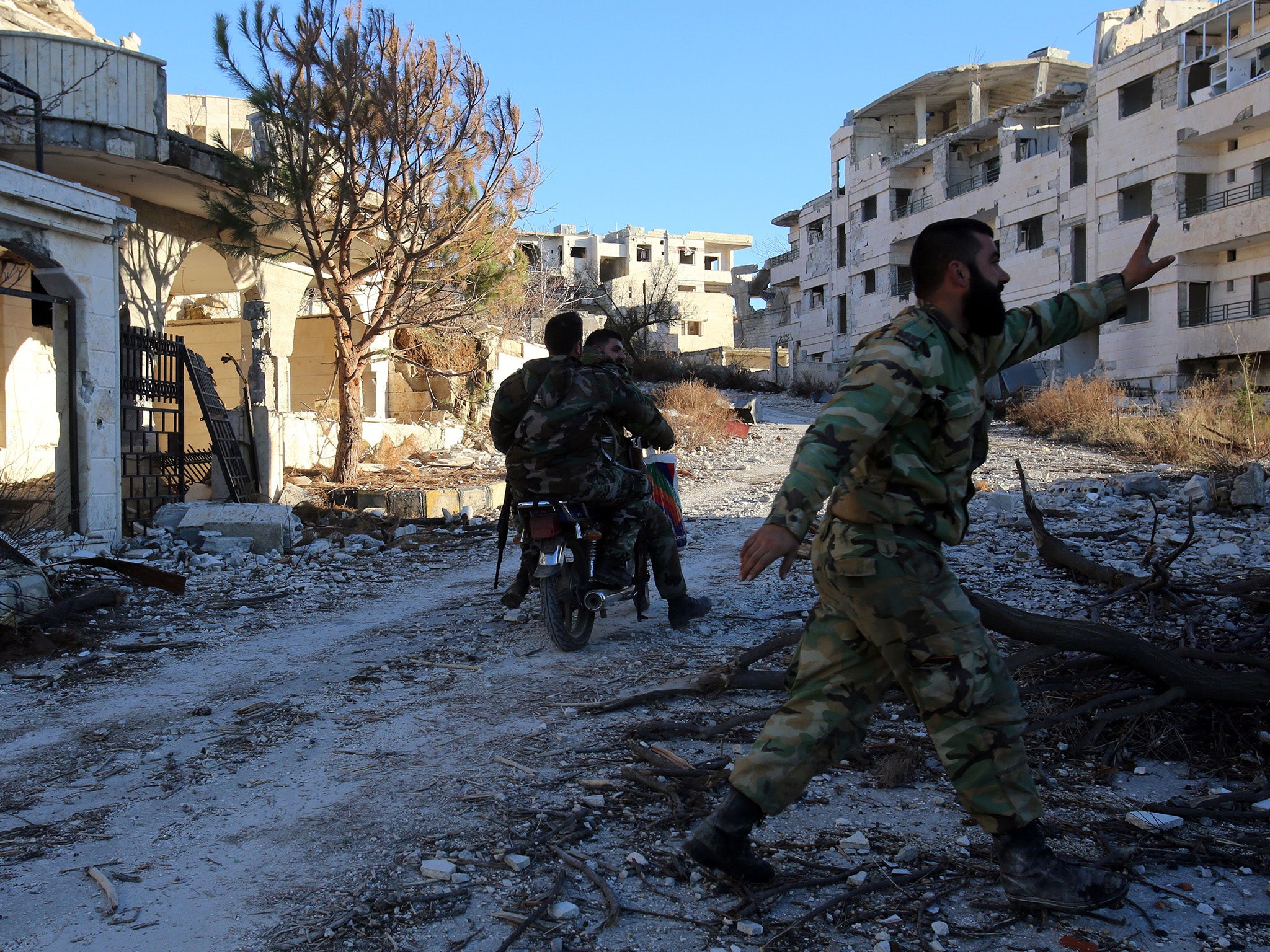 A Syrian government soldier riding through the ruins of nearby Salma which was recaptured on 12 January