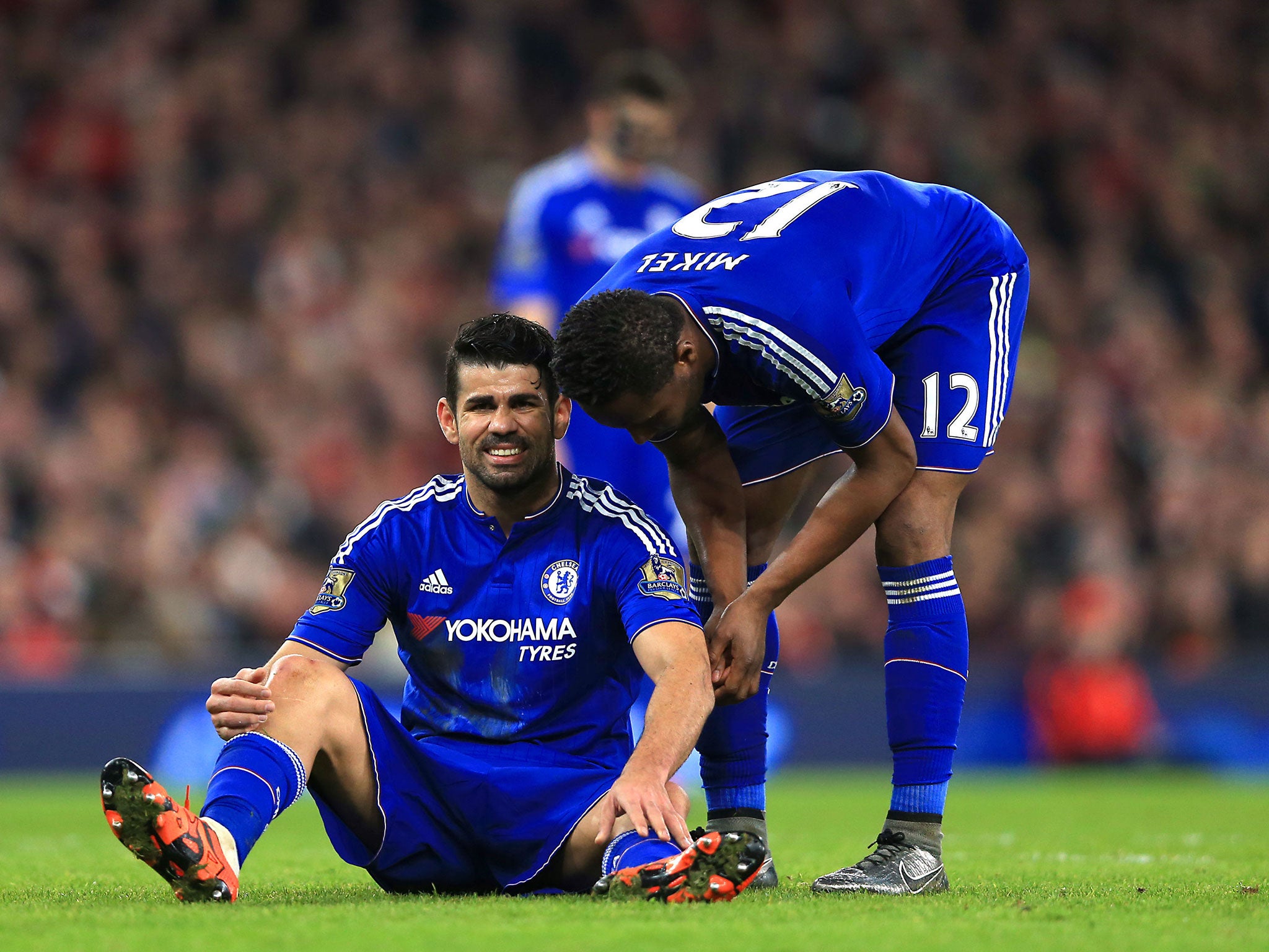 Diego Costa on the floor injured, talking to John Obi-Mikel, shortly before the Spain striker was substituted