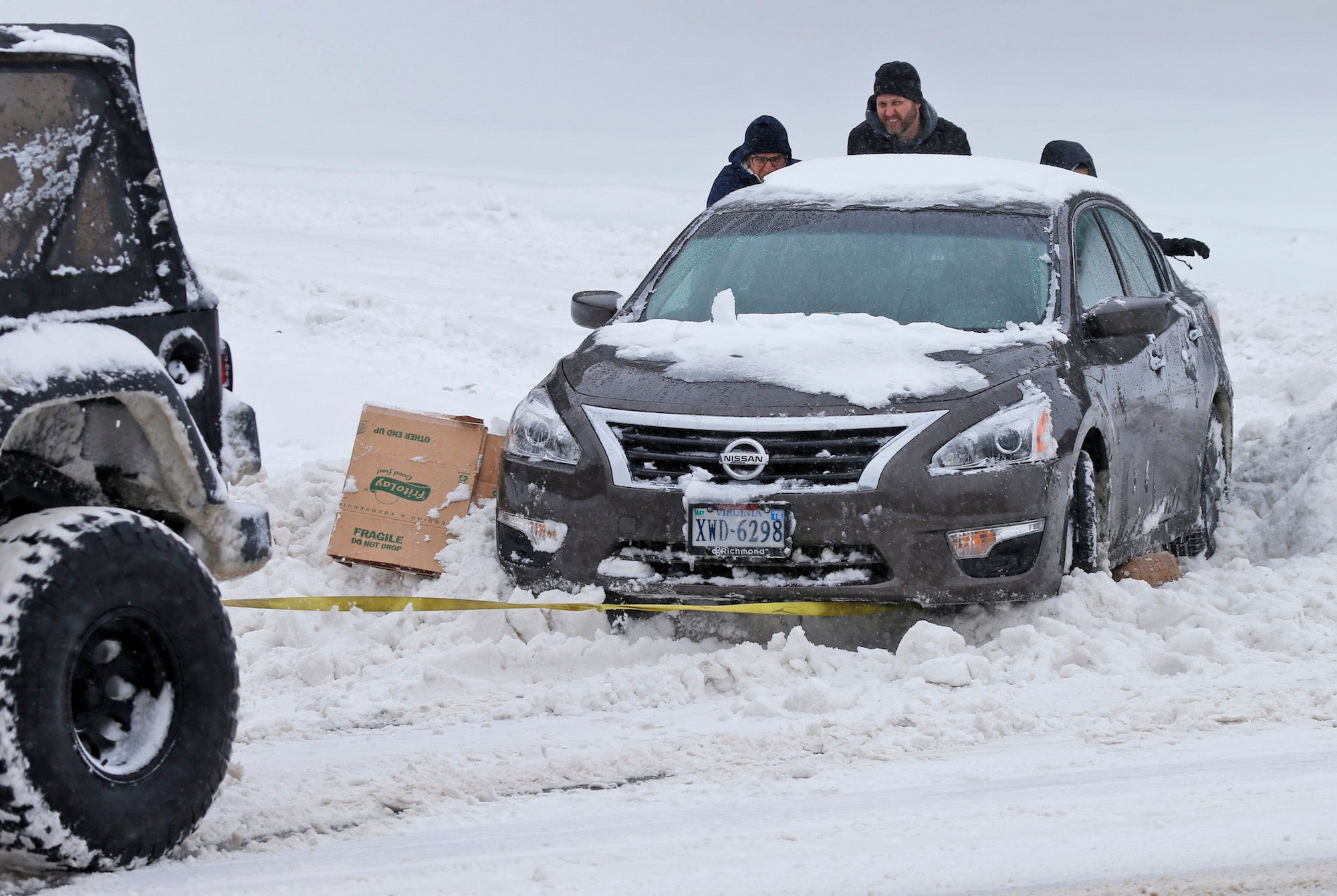 Folks help push a car out of the snow in Richmond, Virginia.