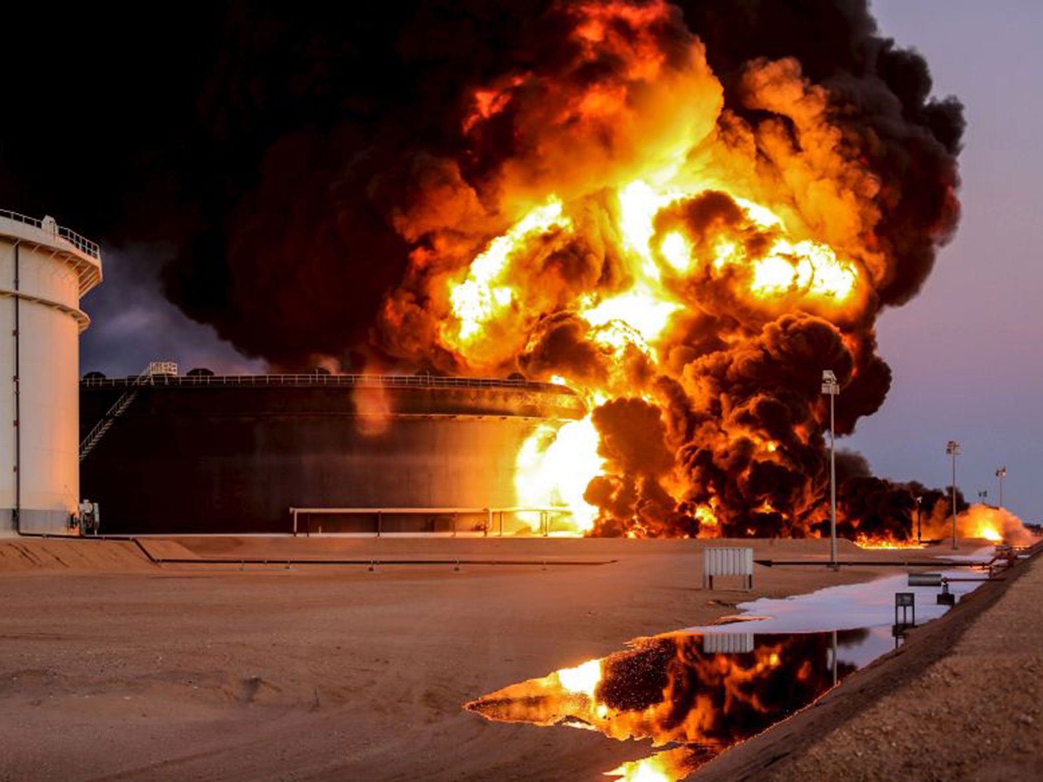 Fire rises from an oil tank in Ras Lanuf, Libya. Attacks against Libya's biggest oil terminals in recent weeks have been lethal and sustained