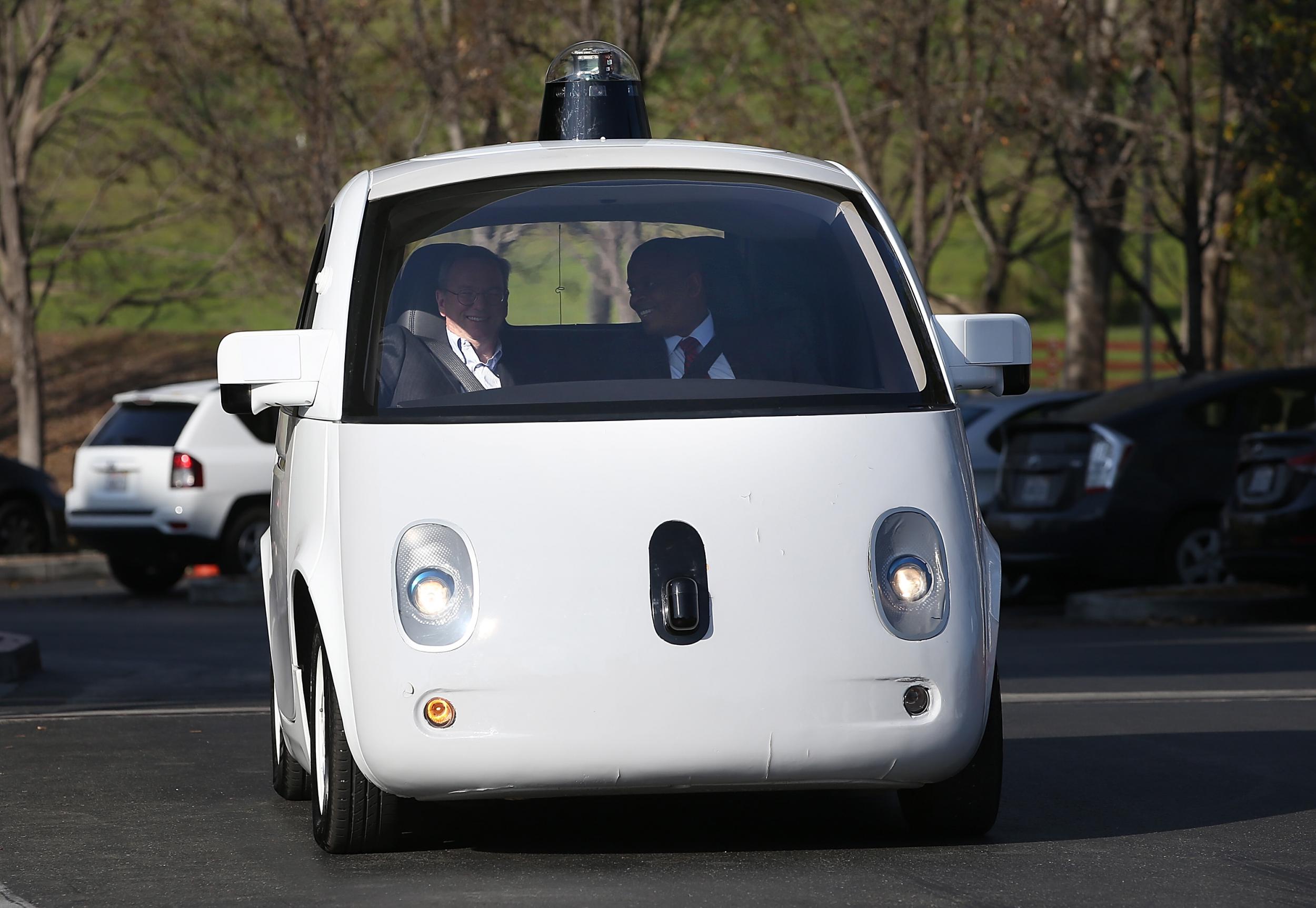 U.S. Transportation Secretary Anthony Foxx and Google Chairman Eric Schmidt ride in a Google self-driving car at the Google headquarters in Mountain View, California in 2015