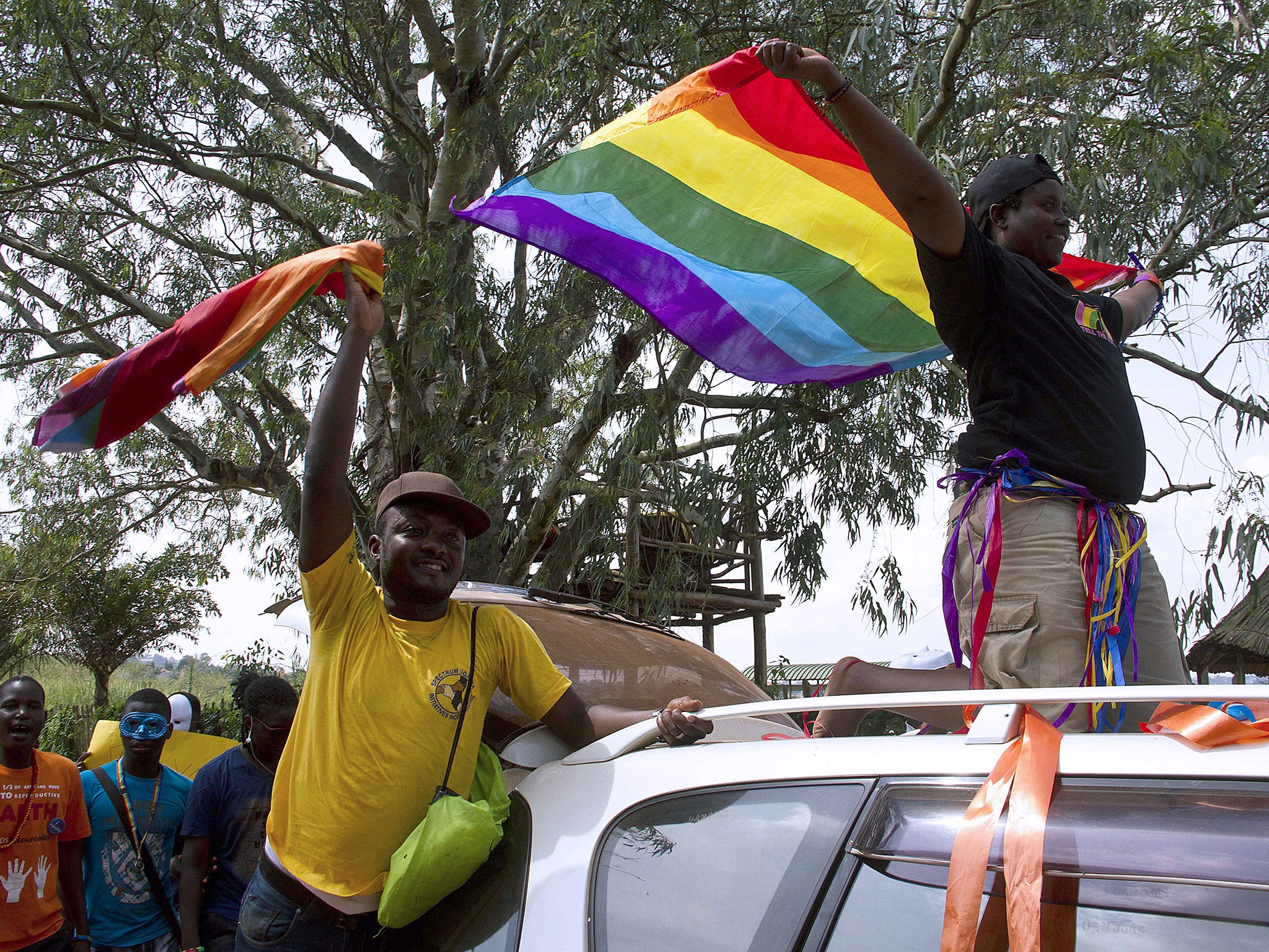 People wave rainbow flag during the the first gay pride rally since the overturning of a tough anti-homosexuality law in Entebbe, Uganda