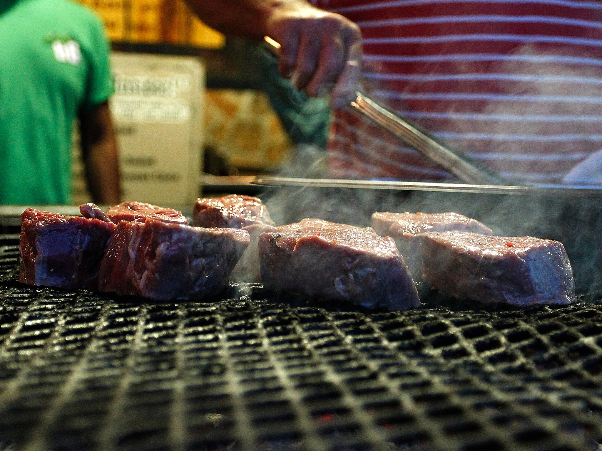 Red meat sizzles on a grill