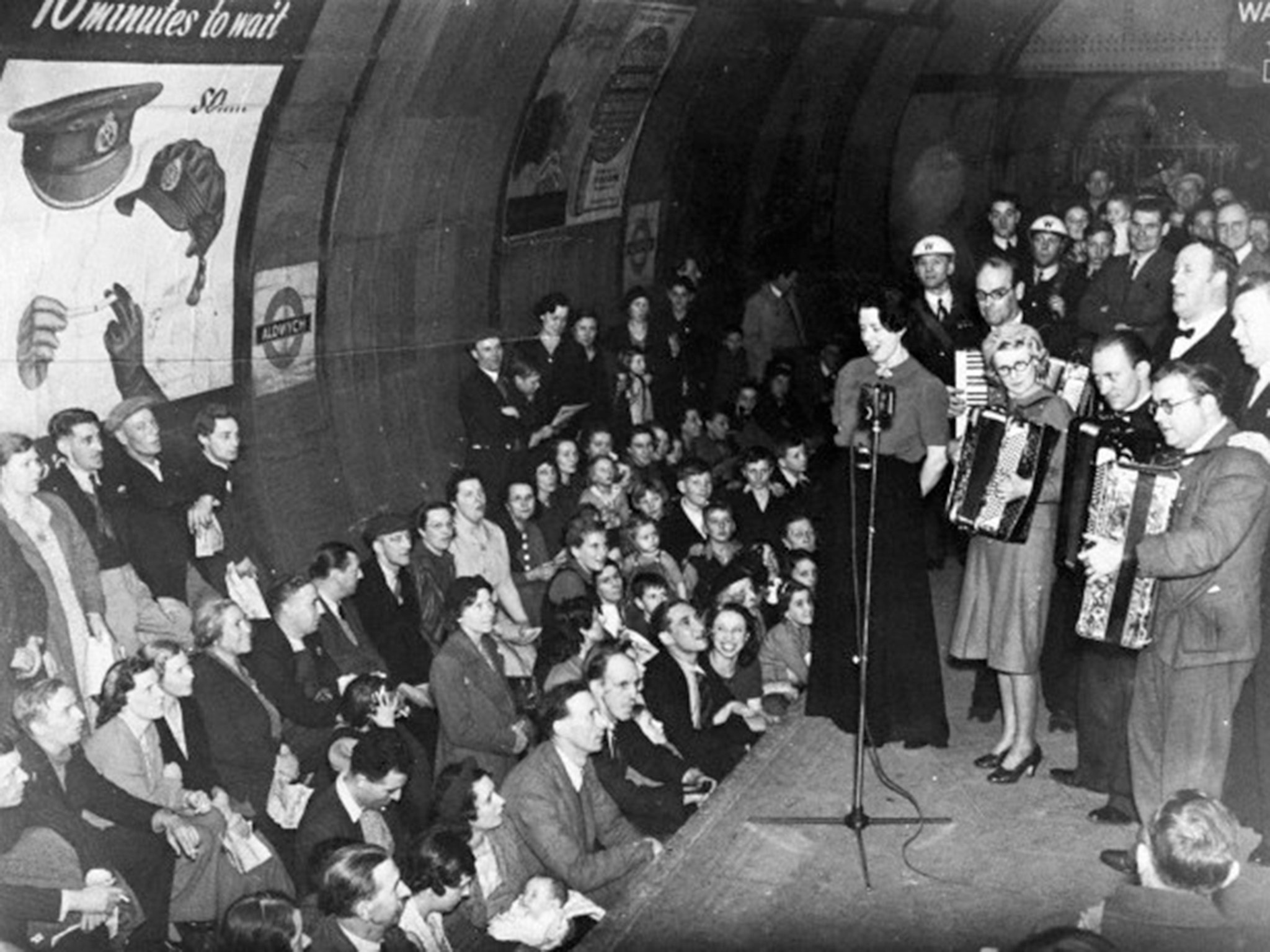 Londoners gather at Aldwych Tube station to listen to music as Nazi bombers fly overhead during the Second World War