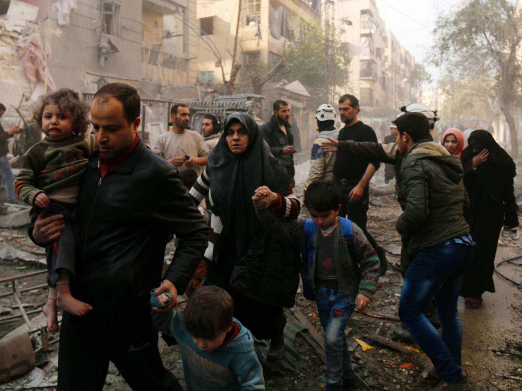 Syrians make their way through debris following air strikes in the rebel-controlled side of the northern city of Aleppo earlier this month