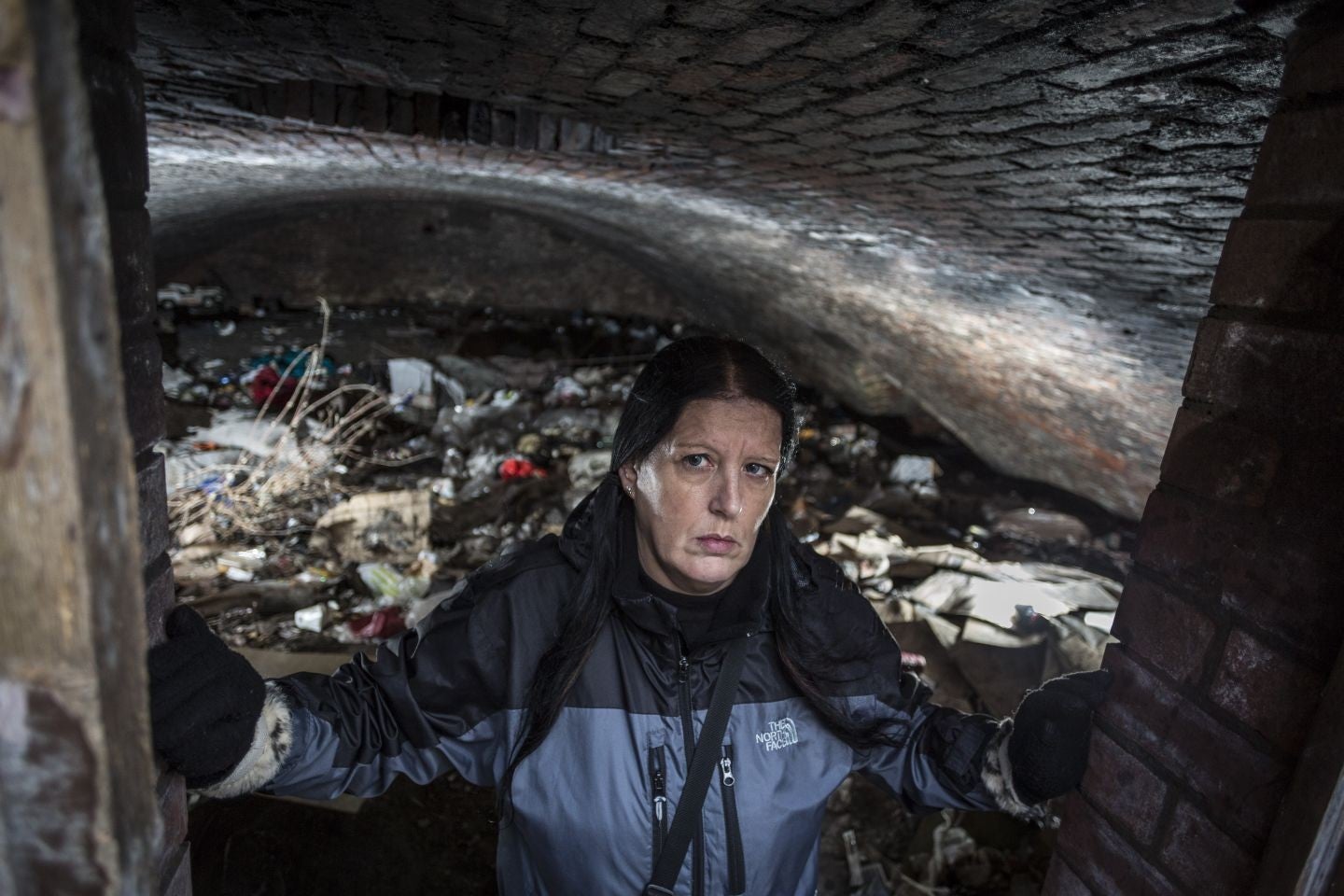 Angela Penny Barratt who works for Street Support Salford pictured in the cave in an enclosed archway near Manchester Cathedral.