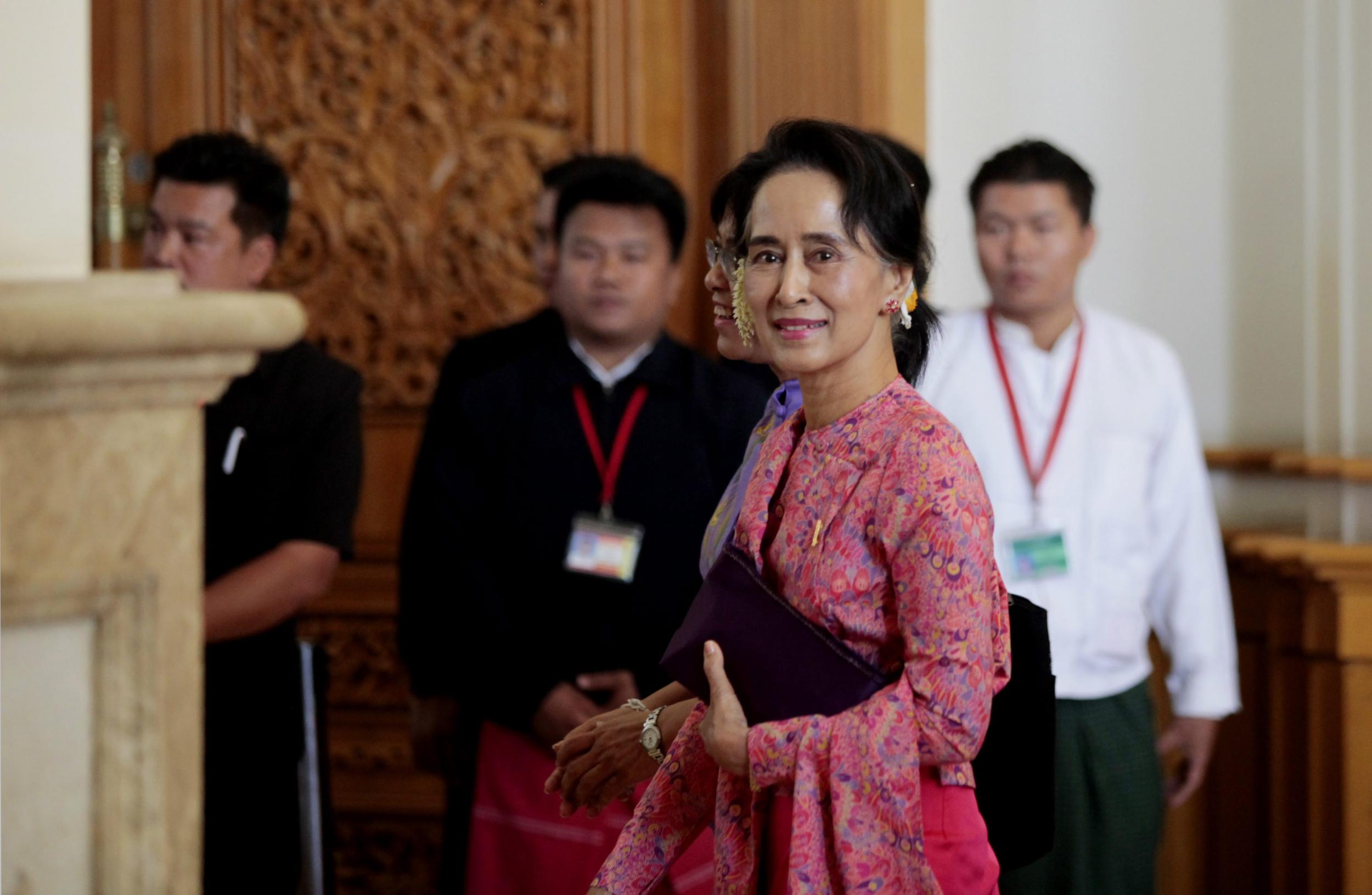 Aung San Suu Kyi (front) leaves after attending the first day of a new parliament session in Naypyitaw