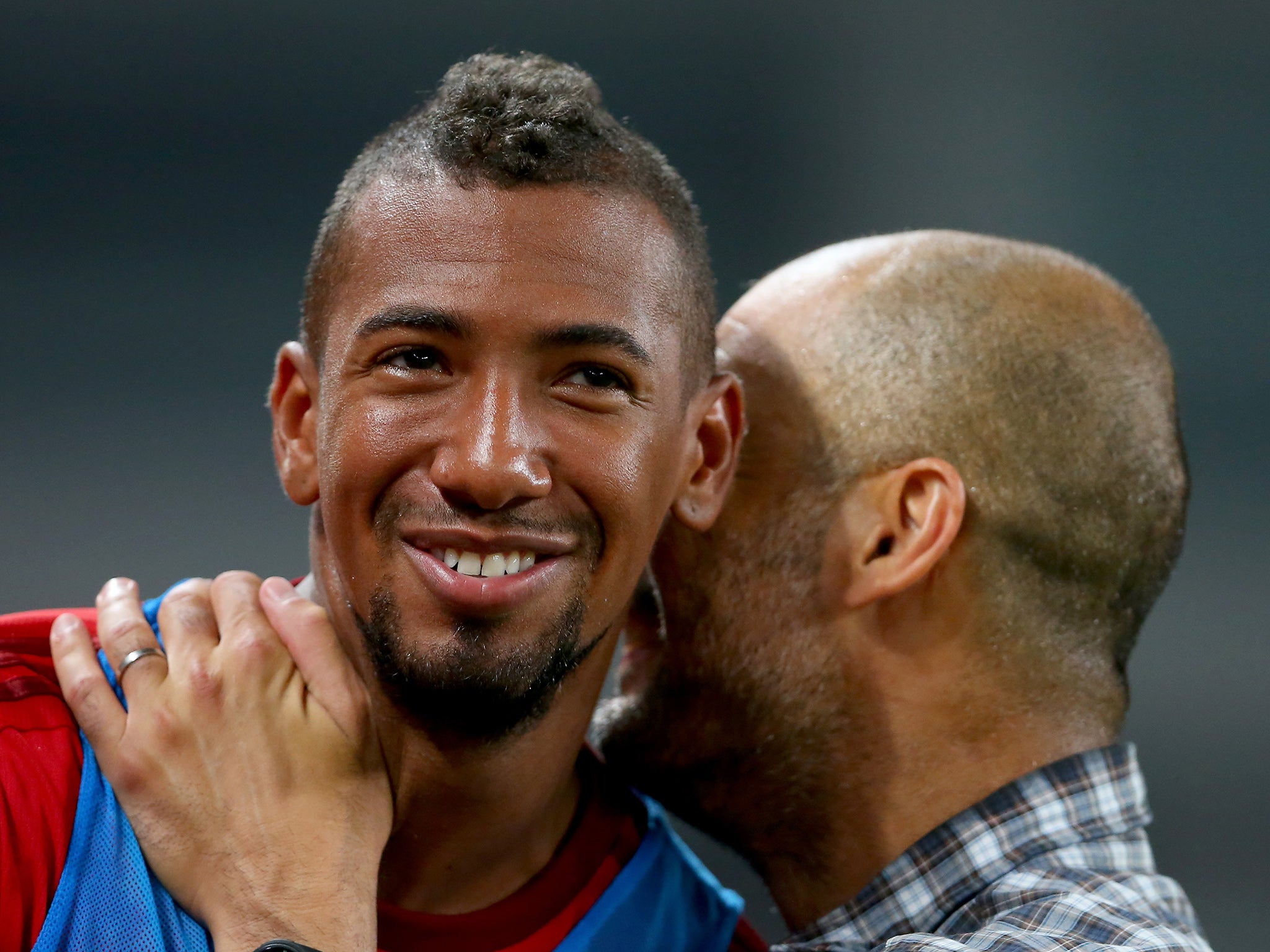 Pep Guardiola speaks with Bayern Munich defender Jerome Boateng