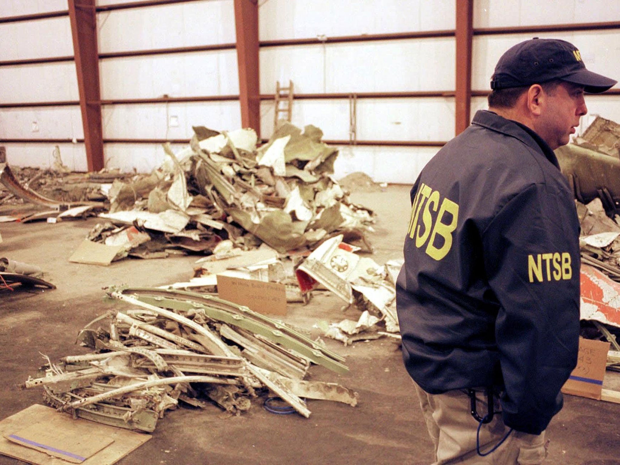 A National Transportation Safety Board Official stands with piles of wreckage from EgyptAir Flight 990, 01 November, 2000