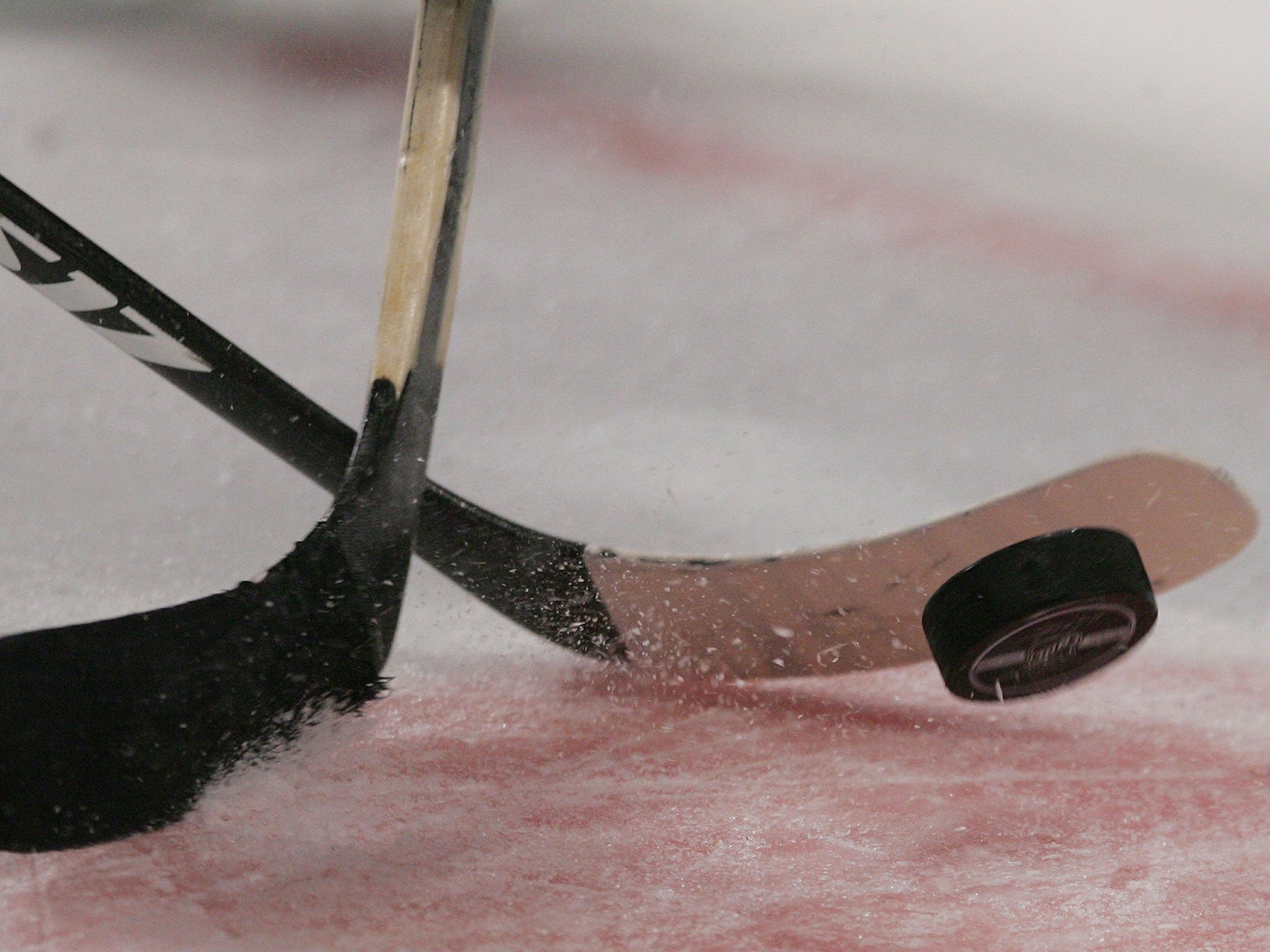 A general view of an ice hockey puck and sticks