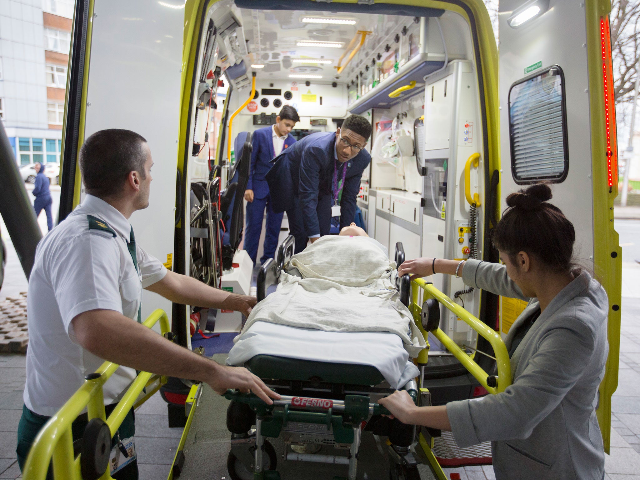 Students transport a ‘patient’ on a stretcher, supervised by Julian Rhodes, head of education with West Midlands Ambulance Service