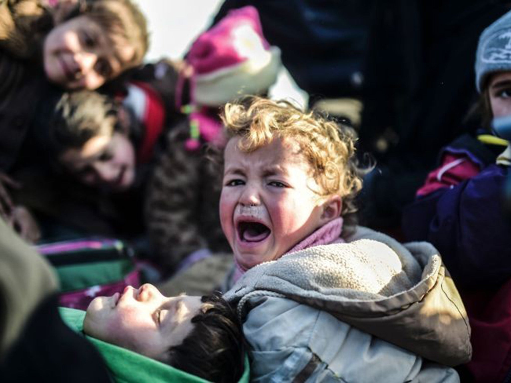 Syrian refugees wait at the closed Bab al-Salam border crossing with Turkey