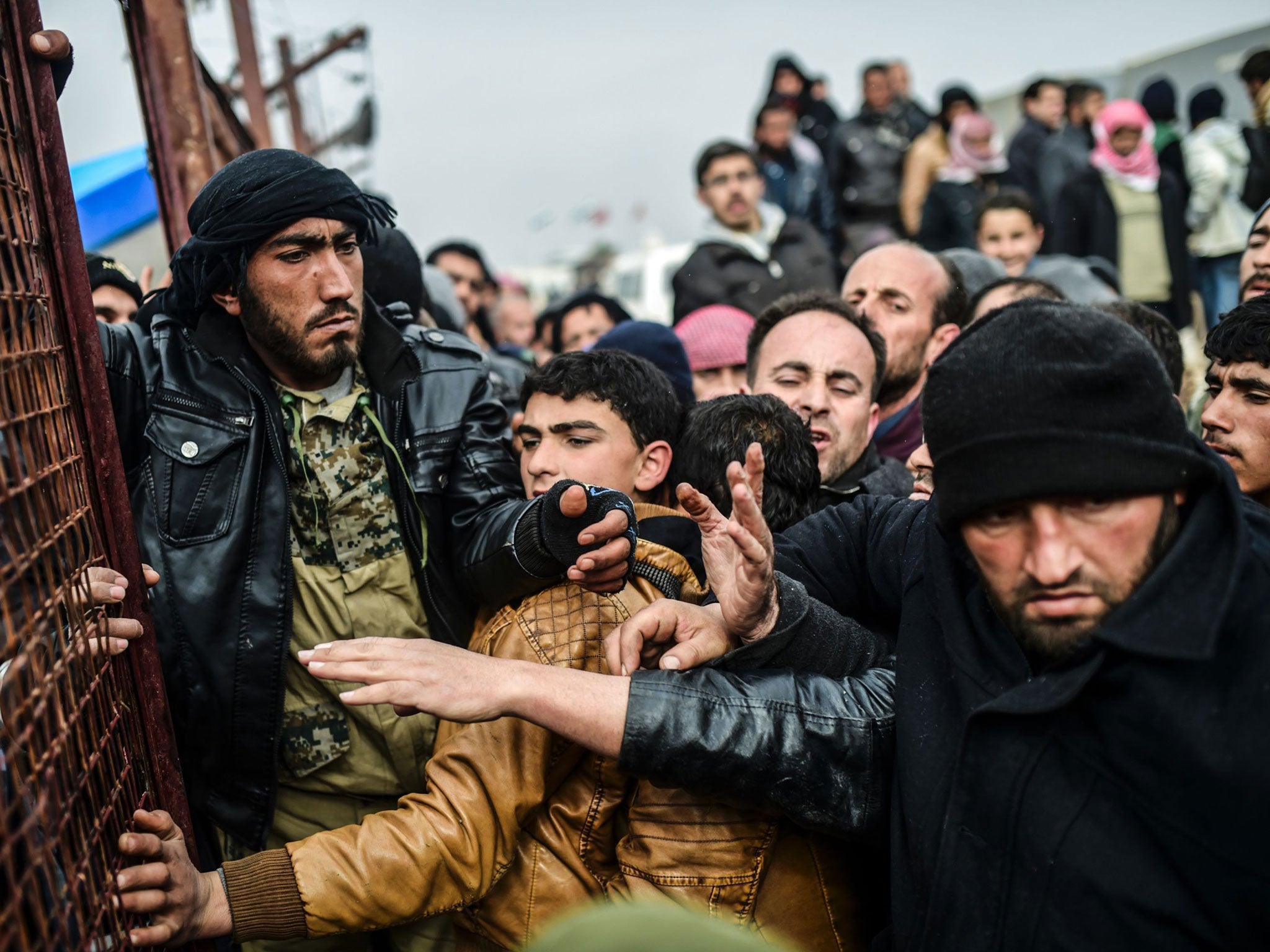 Refugees push each other as they wait for tents at the Bab-Al Salam crossing