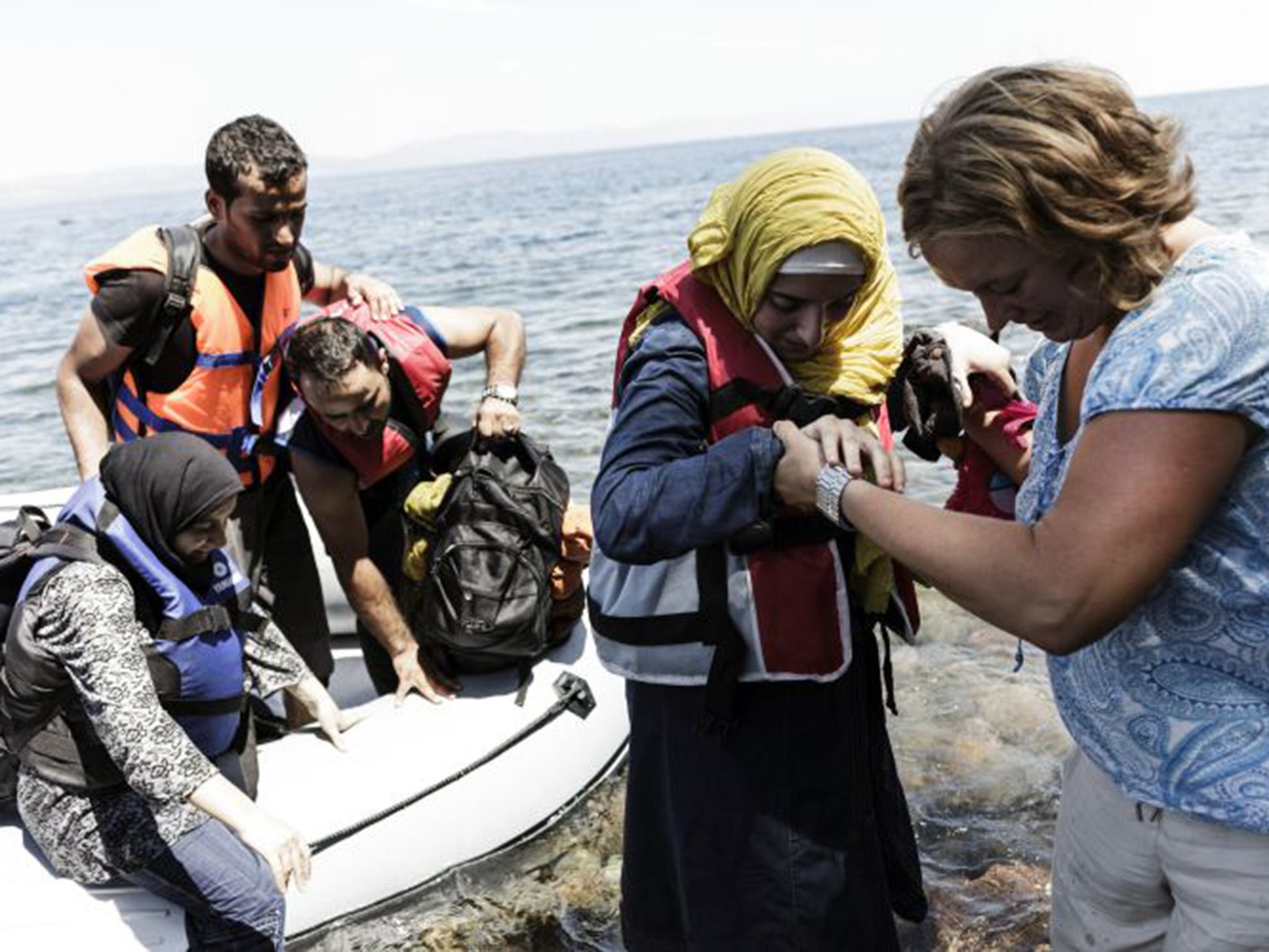 Syrian people arrive on the Greek island of Lesbos after crossing the Aegean sea from Turkey to Greece