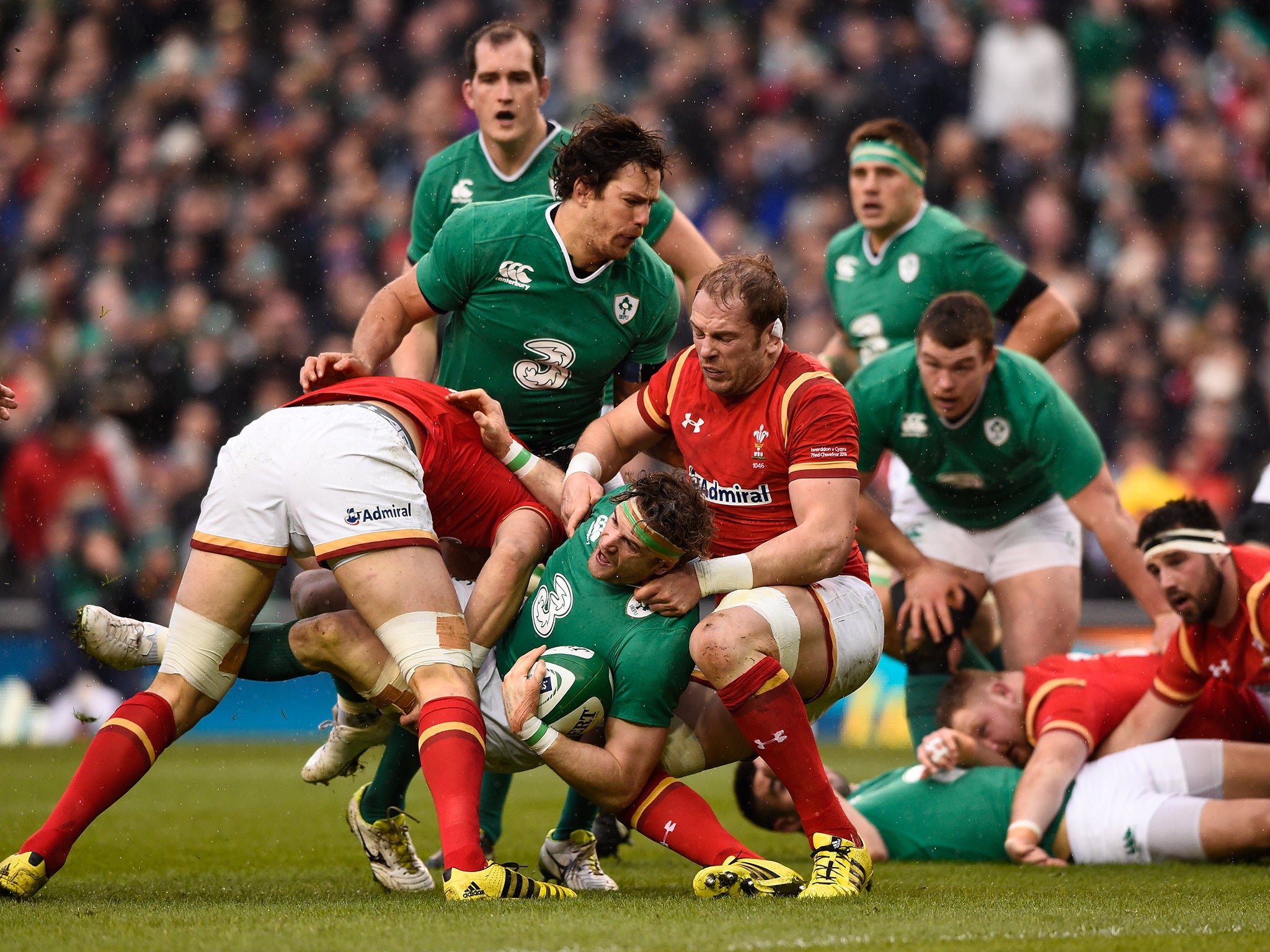 Ireland's Jamie Heaslip is wrapped up by Wales' Luke Charteris and Alun Wyn Jones