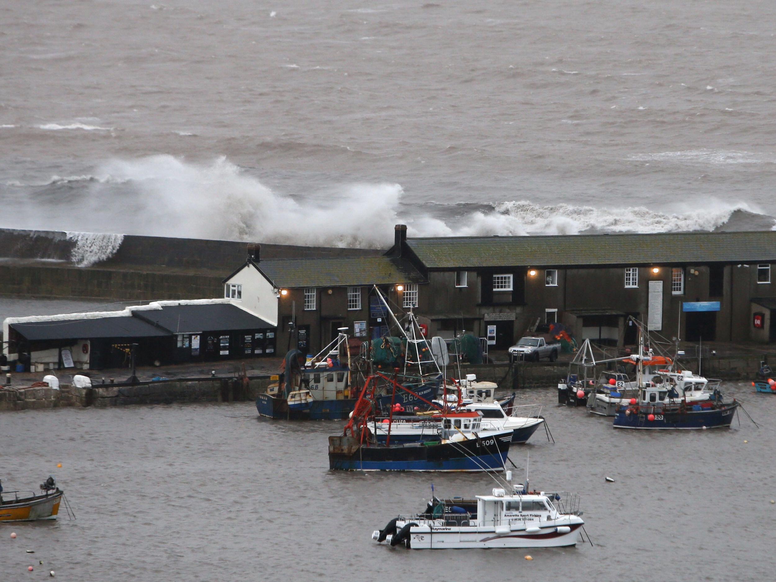 Waves crash against the harbour wall in Lyme Regis, Dorset PA