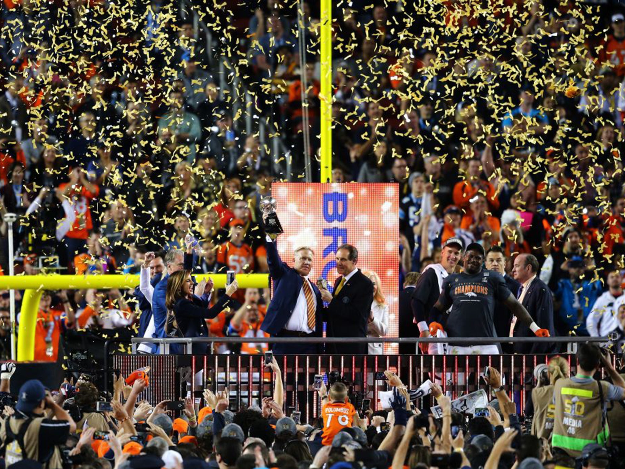 Broncos’ great John Elway holds the trophy as Peyton Manning and Von Miller, right, look on