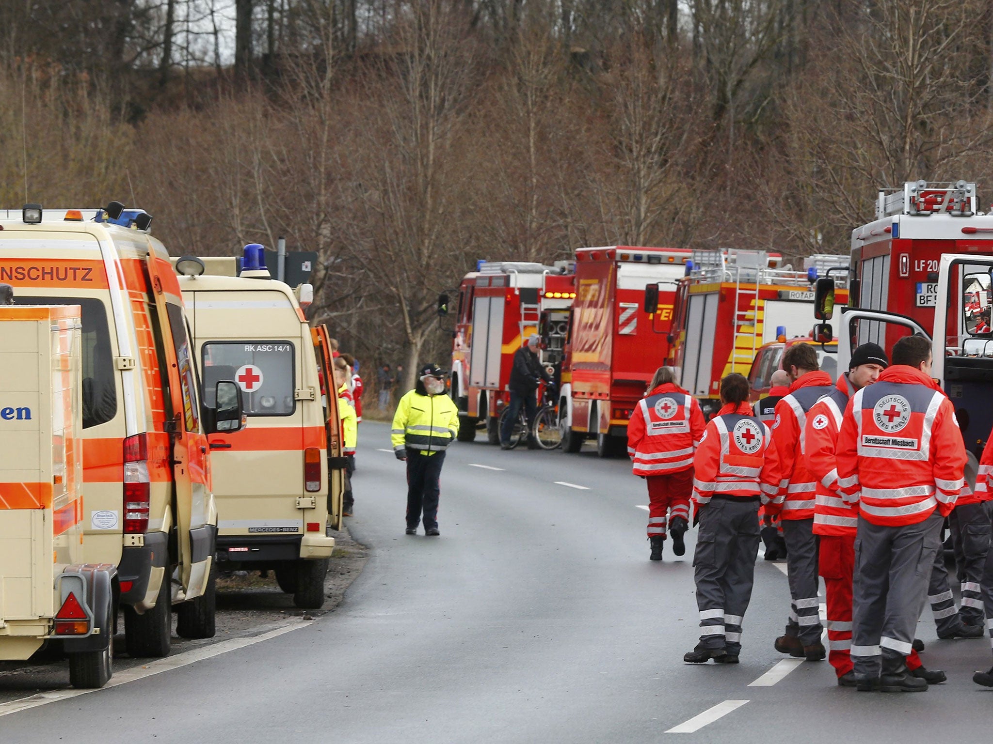 Cars of firefighters and ambulances are parked along a road near Bad Aibling