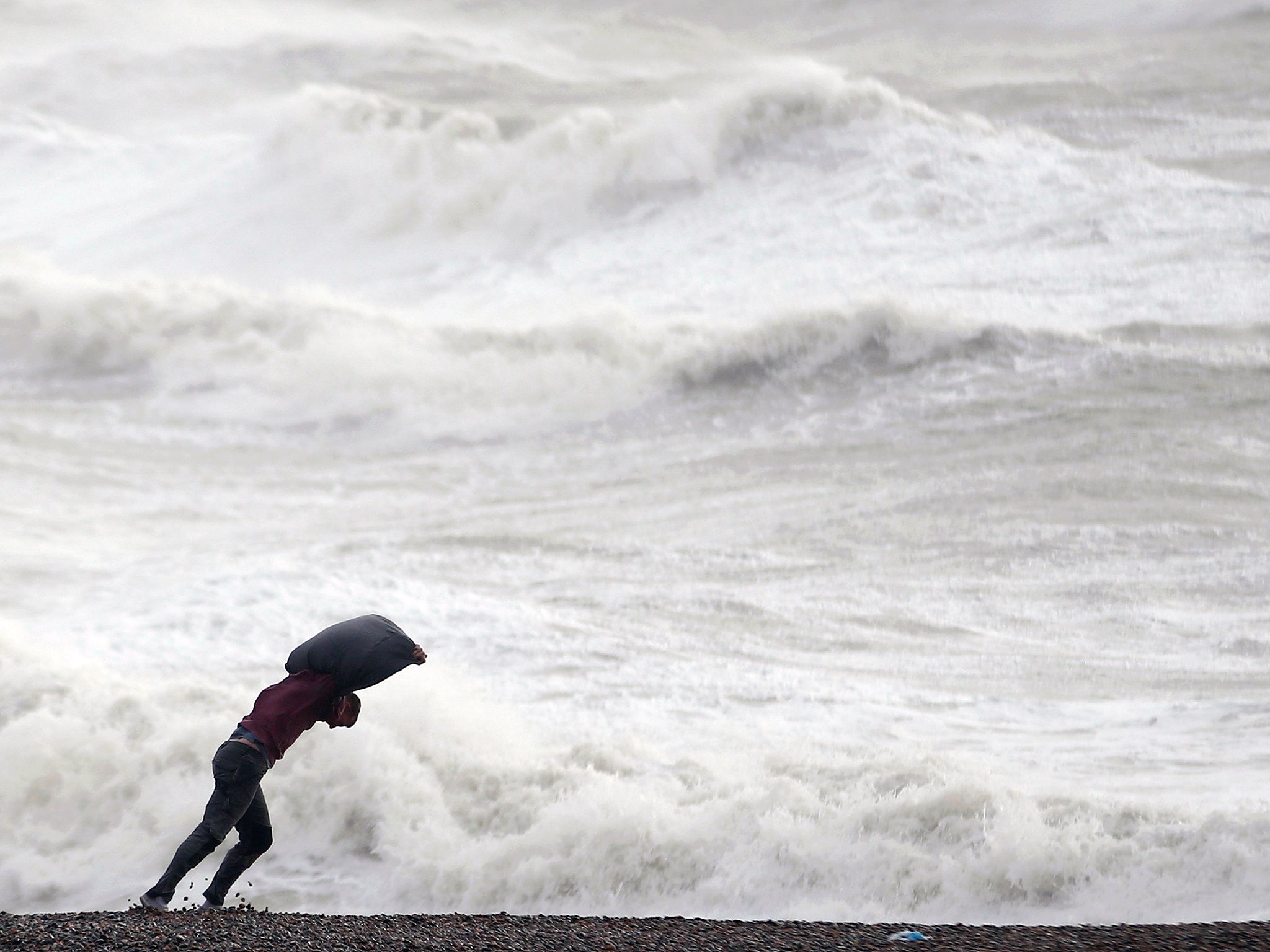 &#13;
A man leans into the wind on the beach at Newhaven&#13;