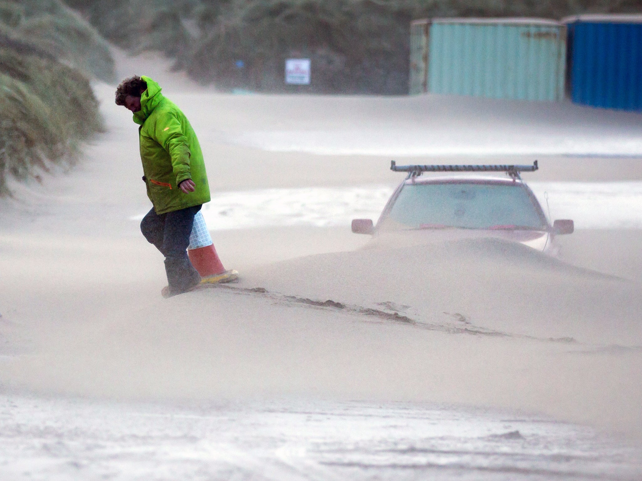 &#13;
A man moves a traffic cone to close Fistral Beach car park because of strong winds in Newquay&#13;