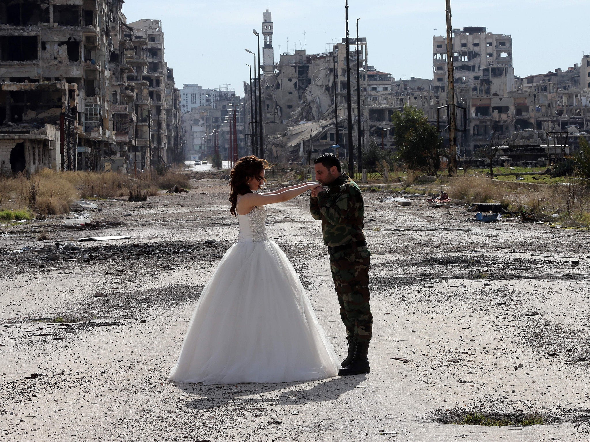 Newlywed Syrian couple Nada Merhi, 18, and Hassan Youssef, 27, pose for a wedding picture amid heavily damaged buildings in the war-ravaged city of Homs.