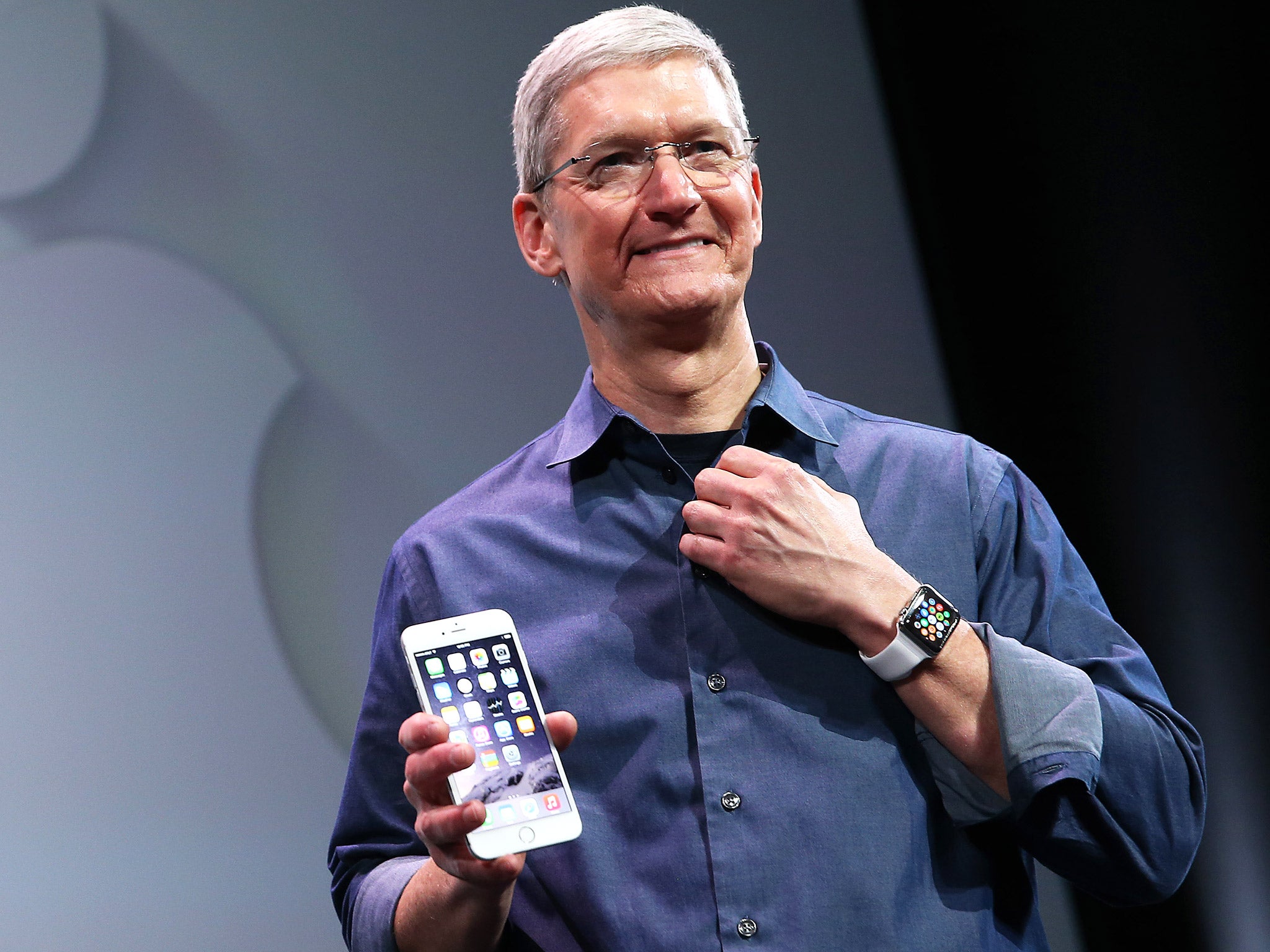 Apple CEO Tim Cook, proudly holding an iPhone 6