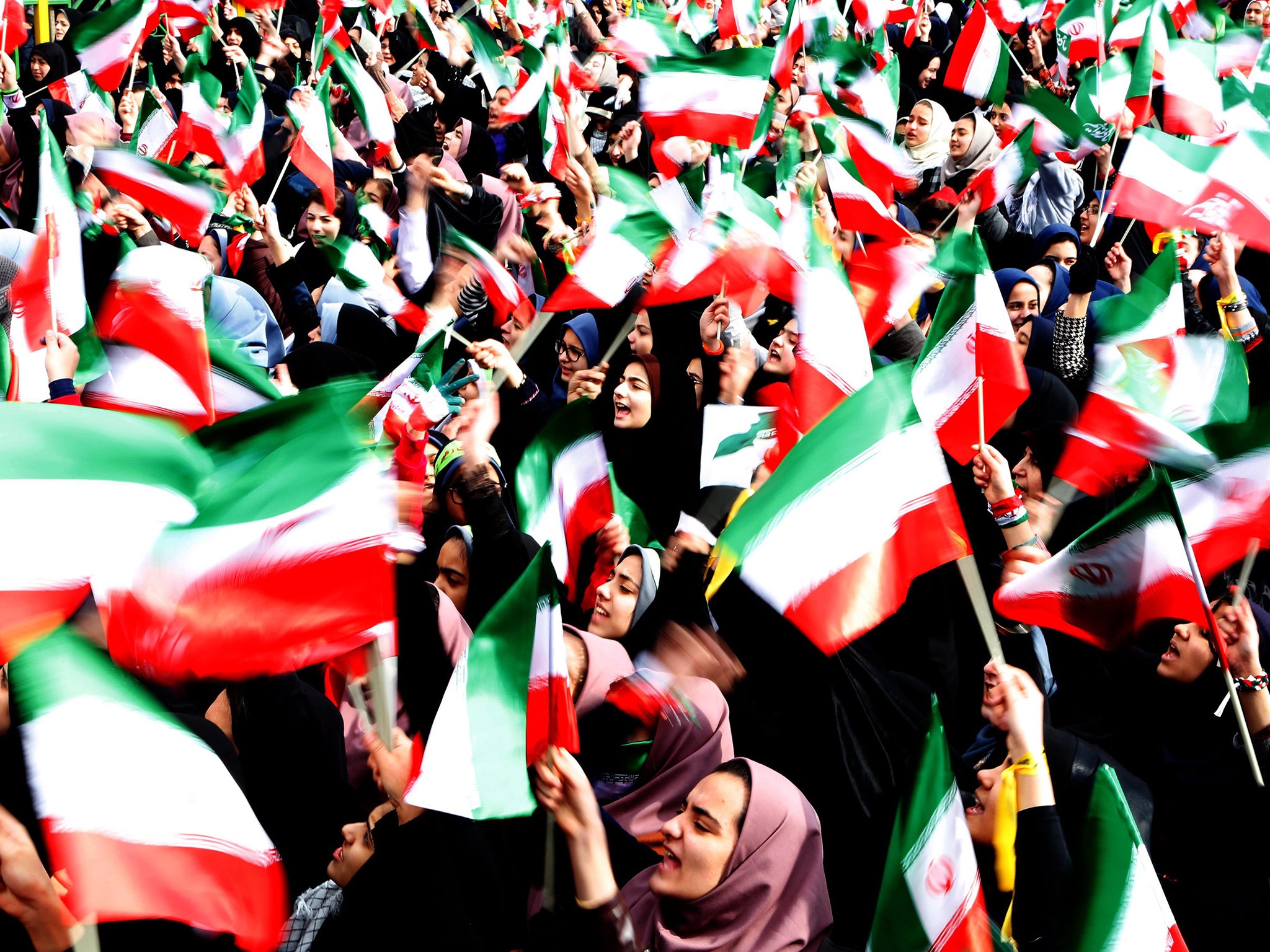 &#13;
Iranian students wave Iran's national flags during a ceremony marking the 37th anniversary of the 1979 Islamic revolution in Tehran (AFP)&#13;