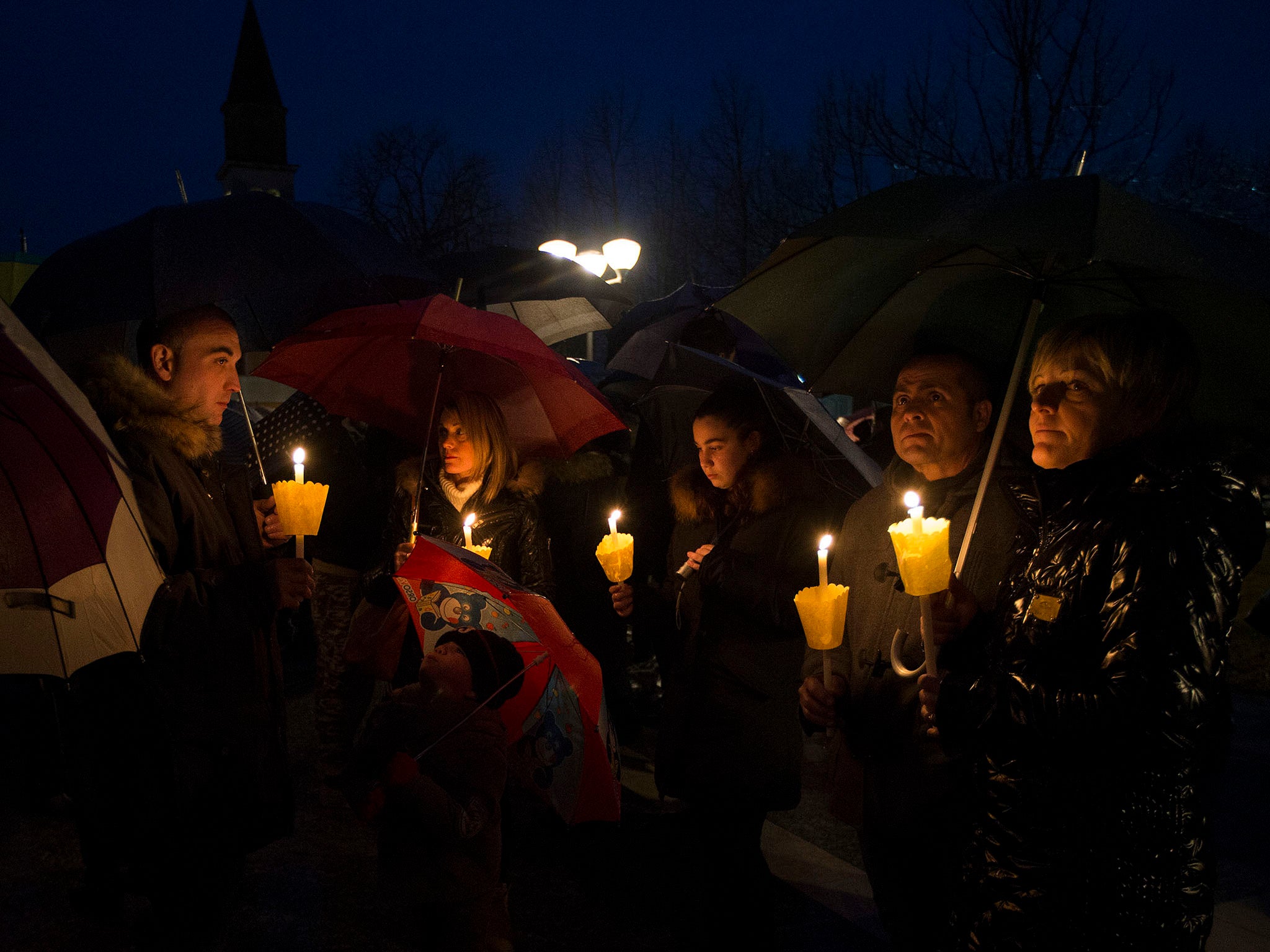 People gather during a candle light procession to honor the memory of Giulio Regeni in Fiumicello, Italy,