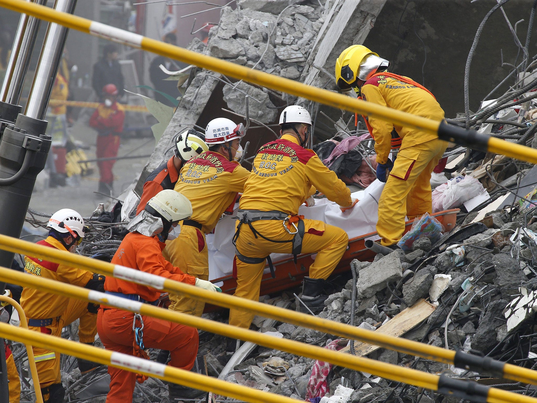 Rescuers pull a dead body from the wreckage