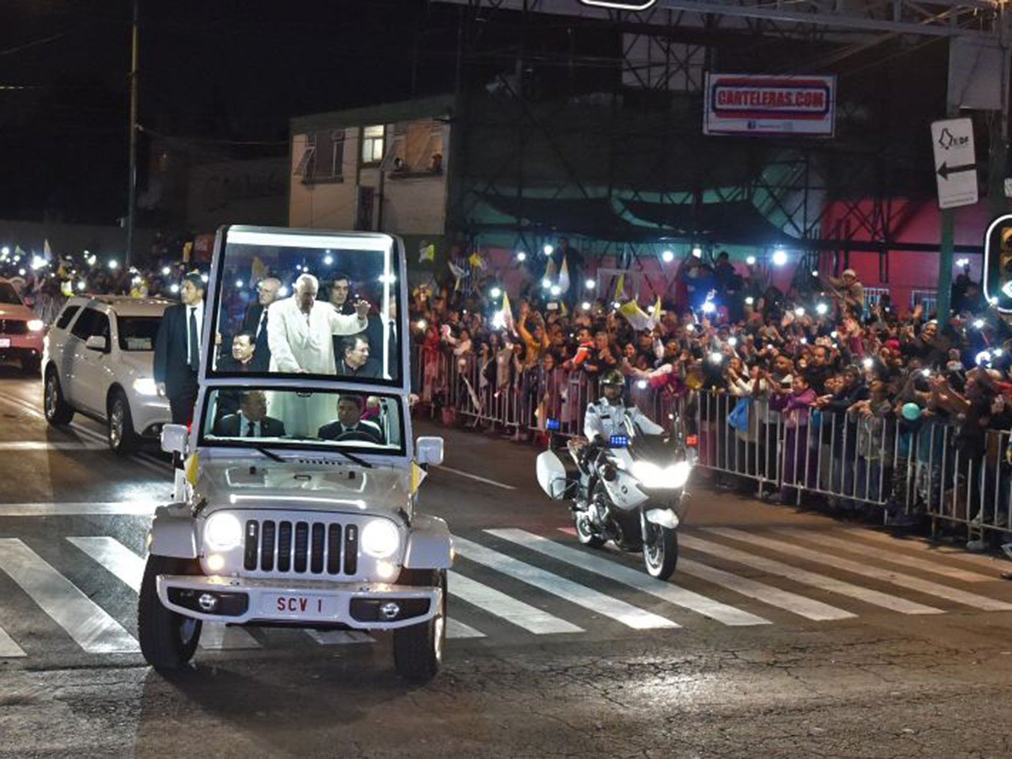 Pope Francis waves from his Popemobile as citizens flock to greet him in Mexico City