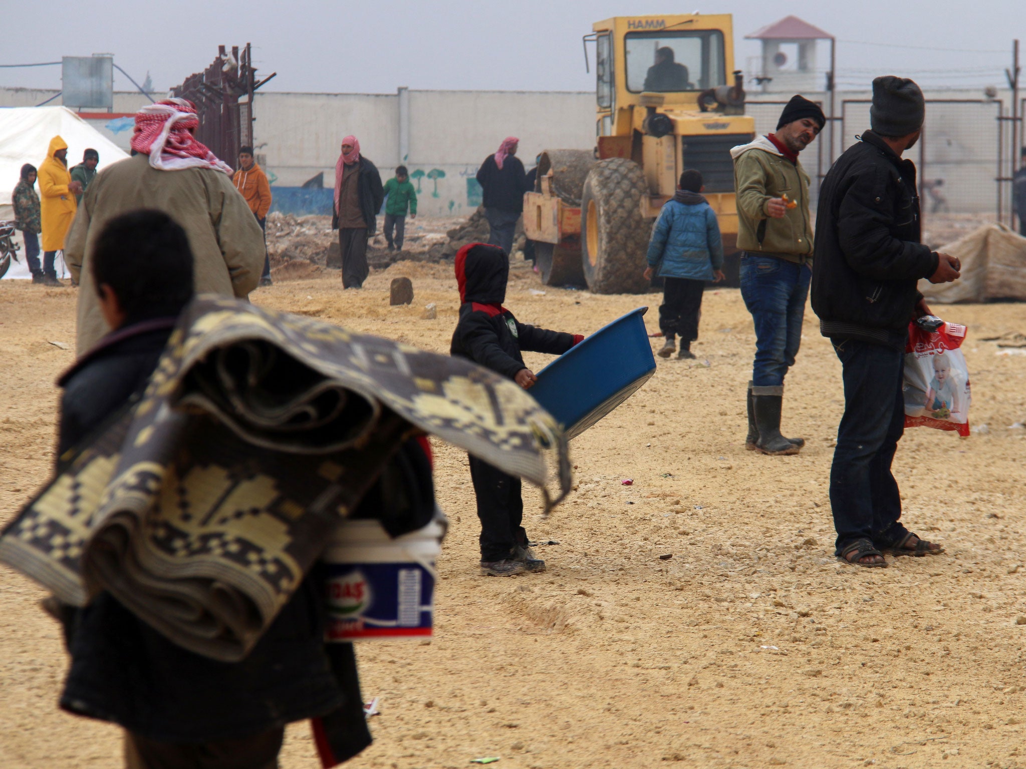 Displaced Syrians fleeing areas in the northern embattled province of Aleppo, gather at the Bab al-Salama camp, set up outside the Syrian city of Azaz on Syria's northern border with Turkey