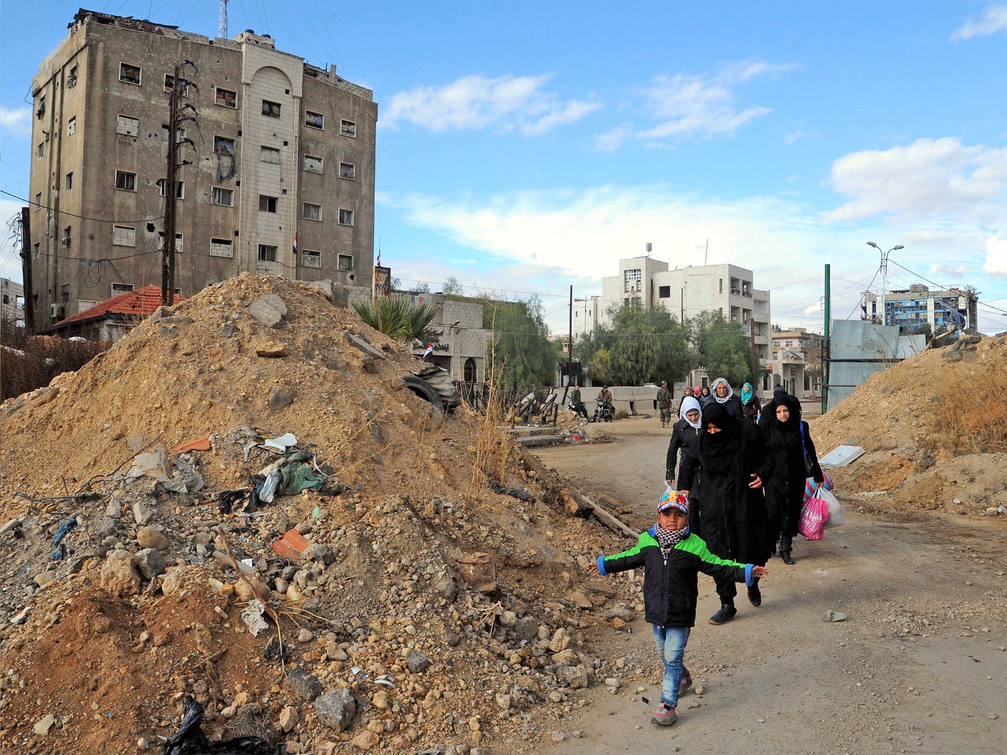 &#13;
Syrian families arrive in the al-Qadam district of Damascus after a truce between government and rebel forces &#13;