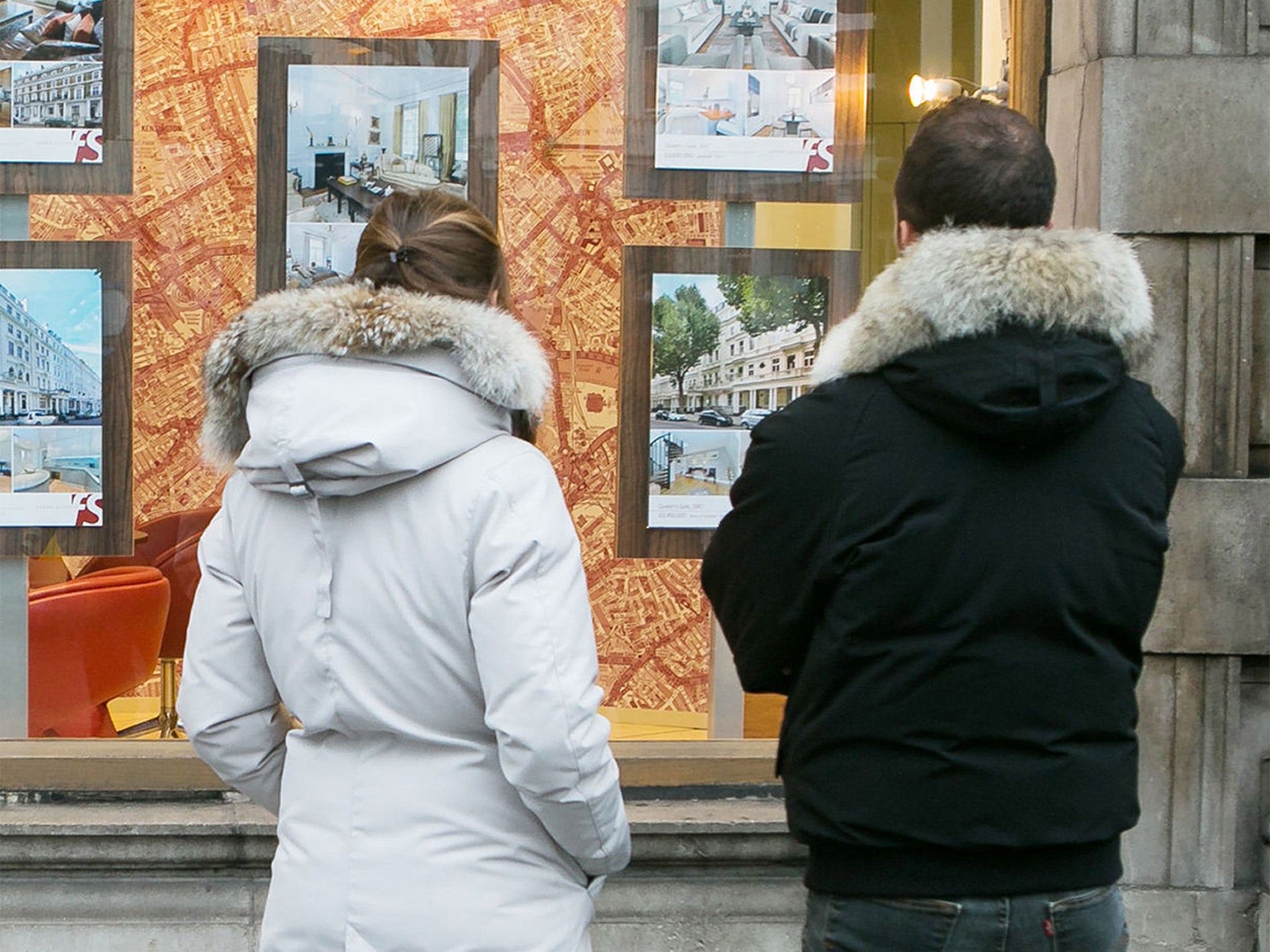 A couple looking in an estate agent window