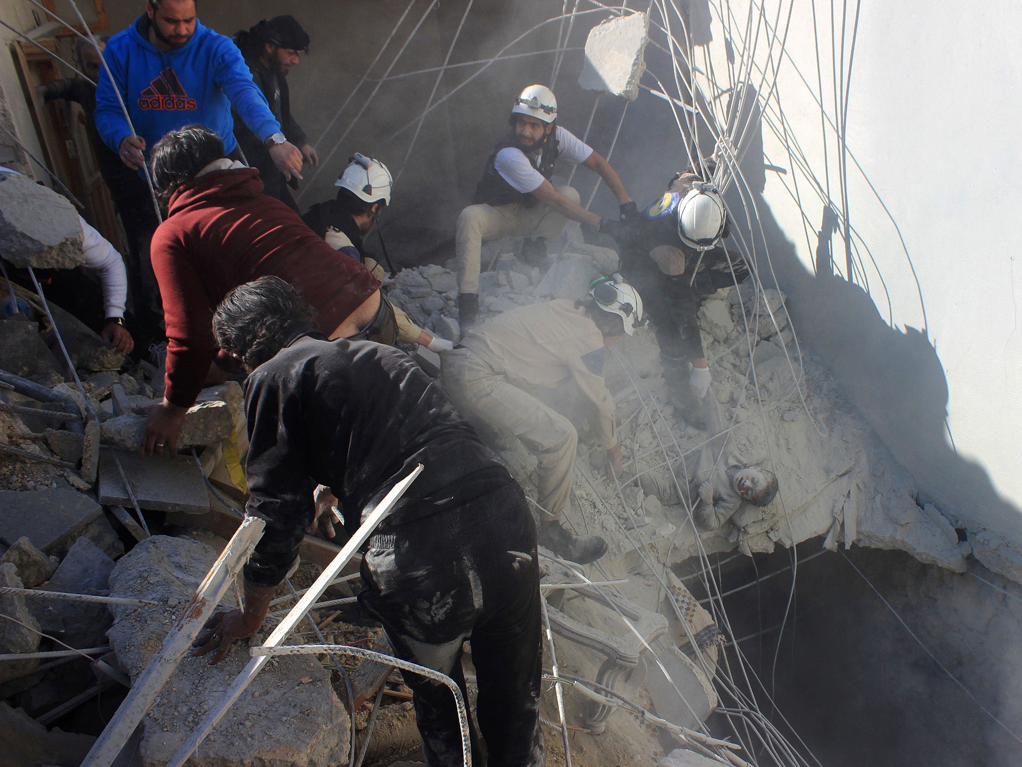 Members of the civil defence pull a boy out from under the rubble of a building following air strikes by suspected Russian warplanes backing the Syrian government on the Sahour neighbourhood of the northern Syrian city of Aleppo on February 16, 2016.