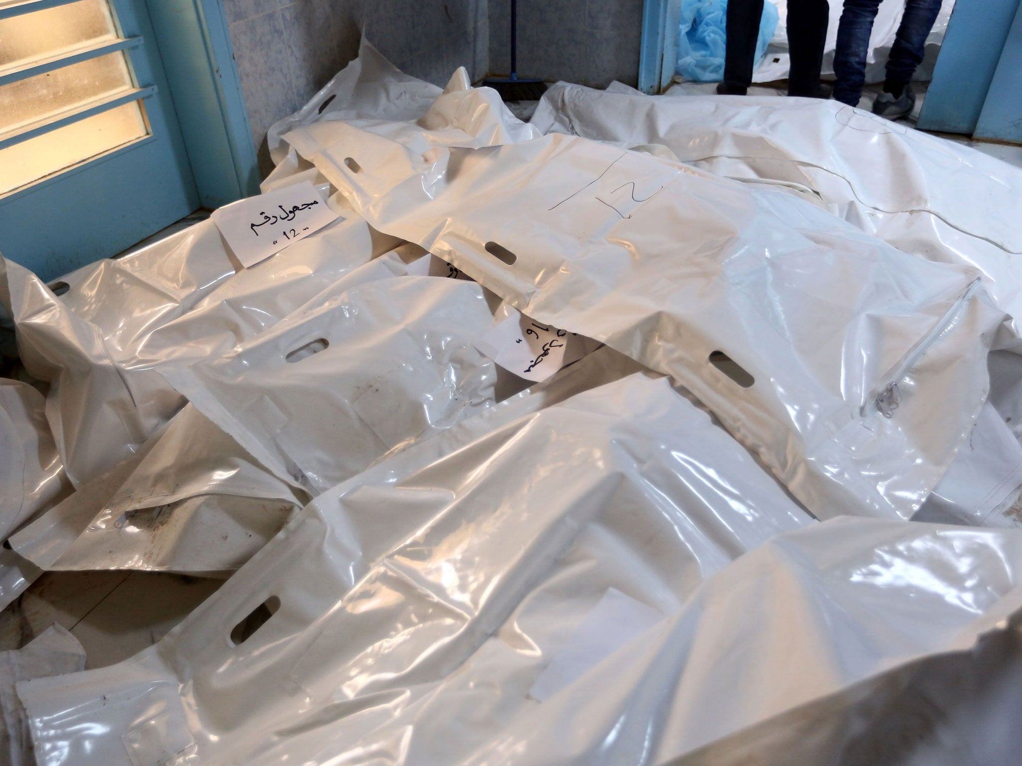 Bodies wrapped in plastic bags lie on the ground at a hospital in Sabratha, on February 20, 2016, a day after a US air strike targeted a jihadist training camp near the Libyan coastal city.