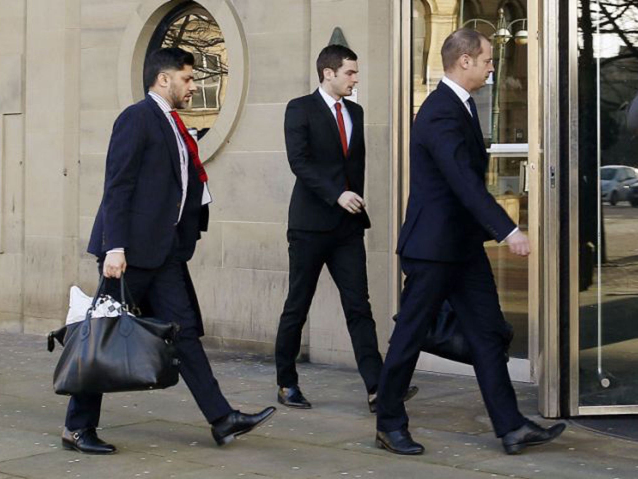 Footballer Adam Johnson, centre, arrives at Bradford Crown Court with his legal team to give evidence for the first time in his trial