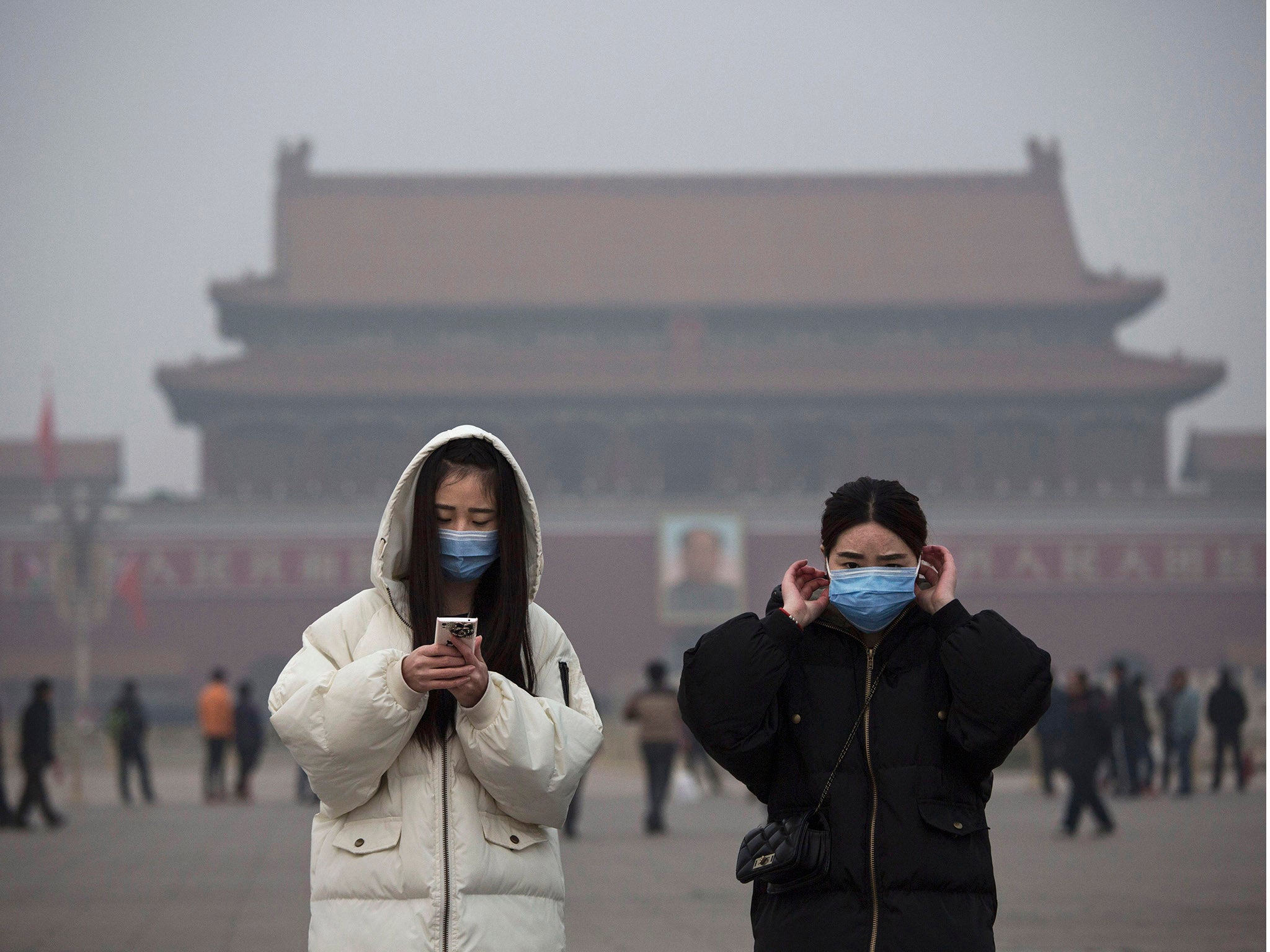 Women wear masks to protect against pollution as they visit Tiananmen Square during smog in Beijing, China.