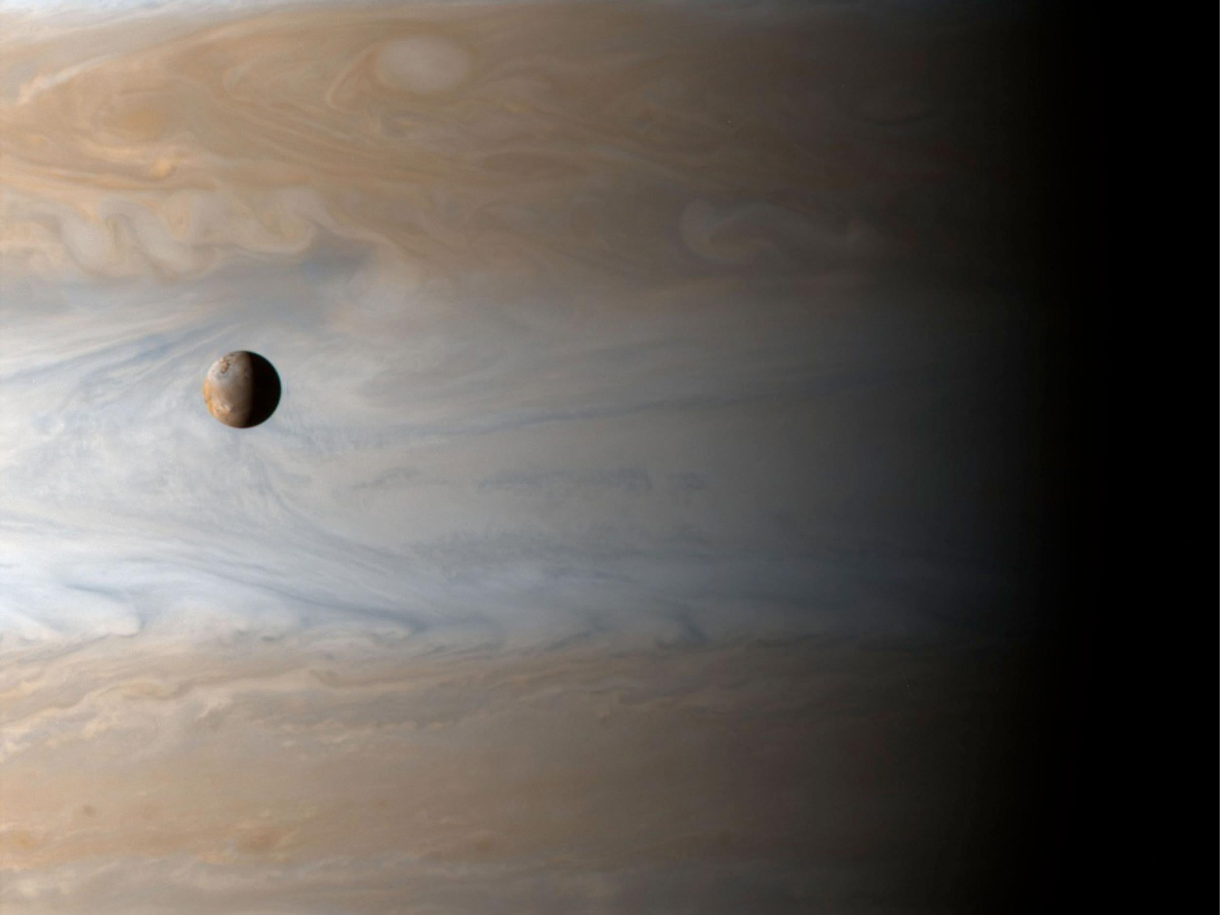 An image of Jupiter with one of its moons, Io, in the foreground, taken by the Cassini probe in 2001