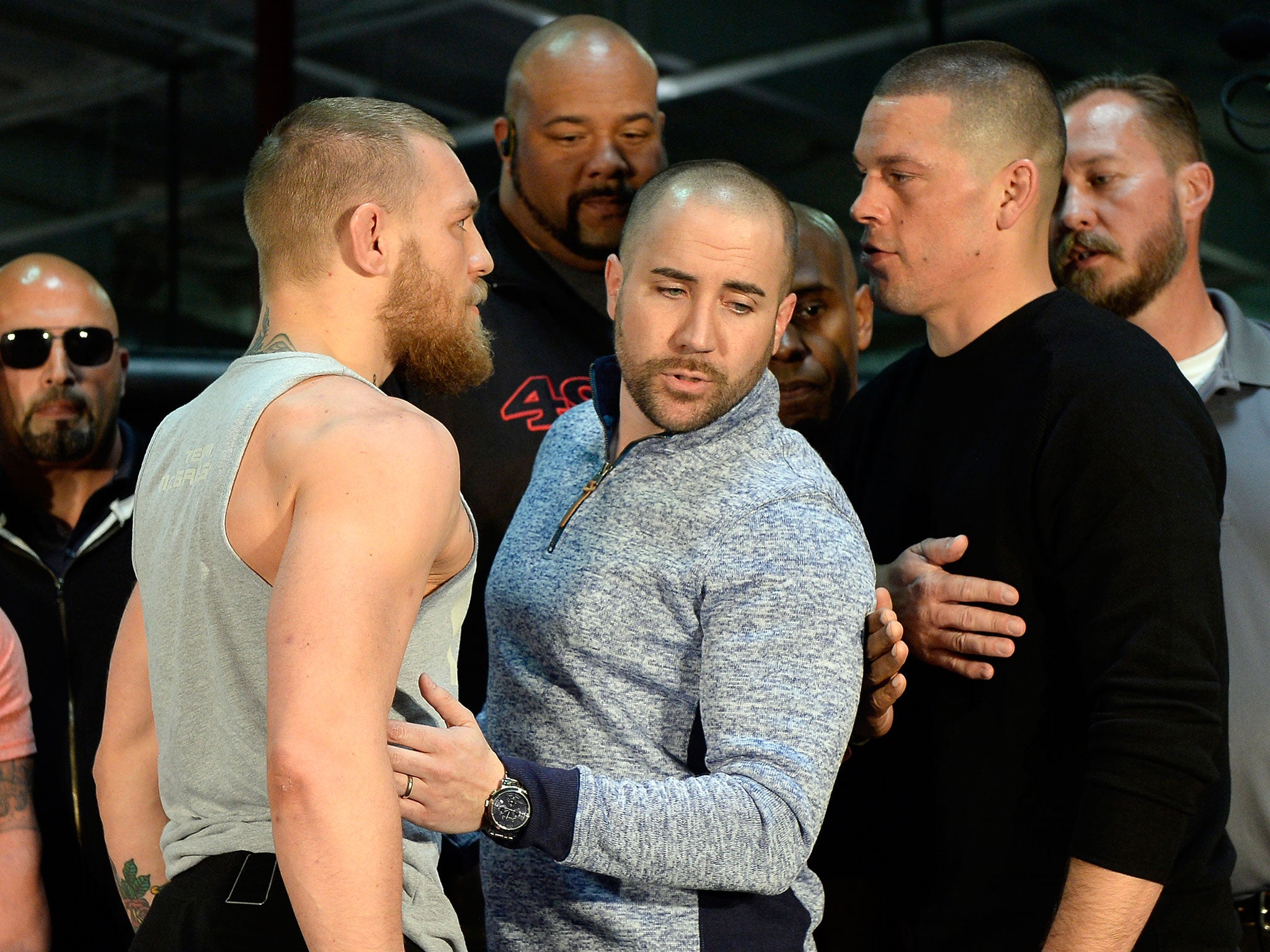 UFC featherweight champion Conor McGregor (L) and lightweight contender Nate Diaz square off ahead of their UFC 196 fight