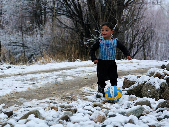 Murtaza playing football in his homemade shirt