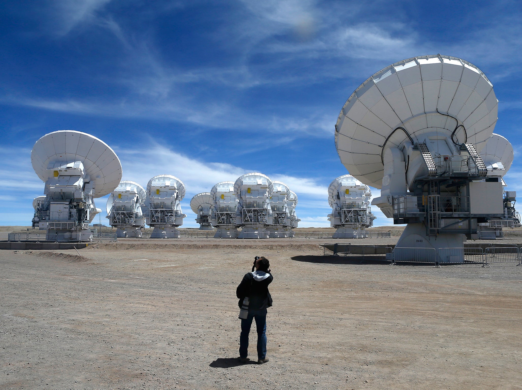 A member of the media takes pictures of the parabolic antennas of the ALMA (Atacama Large Millimetre/Submillimetre Array) project at the El Llano de Chajnantor in the Atacama desert, some 1730 km (1074 miles) north of Santiago and 5000 metres above sea level, March 12, 2013