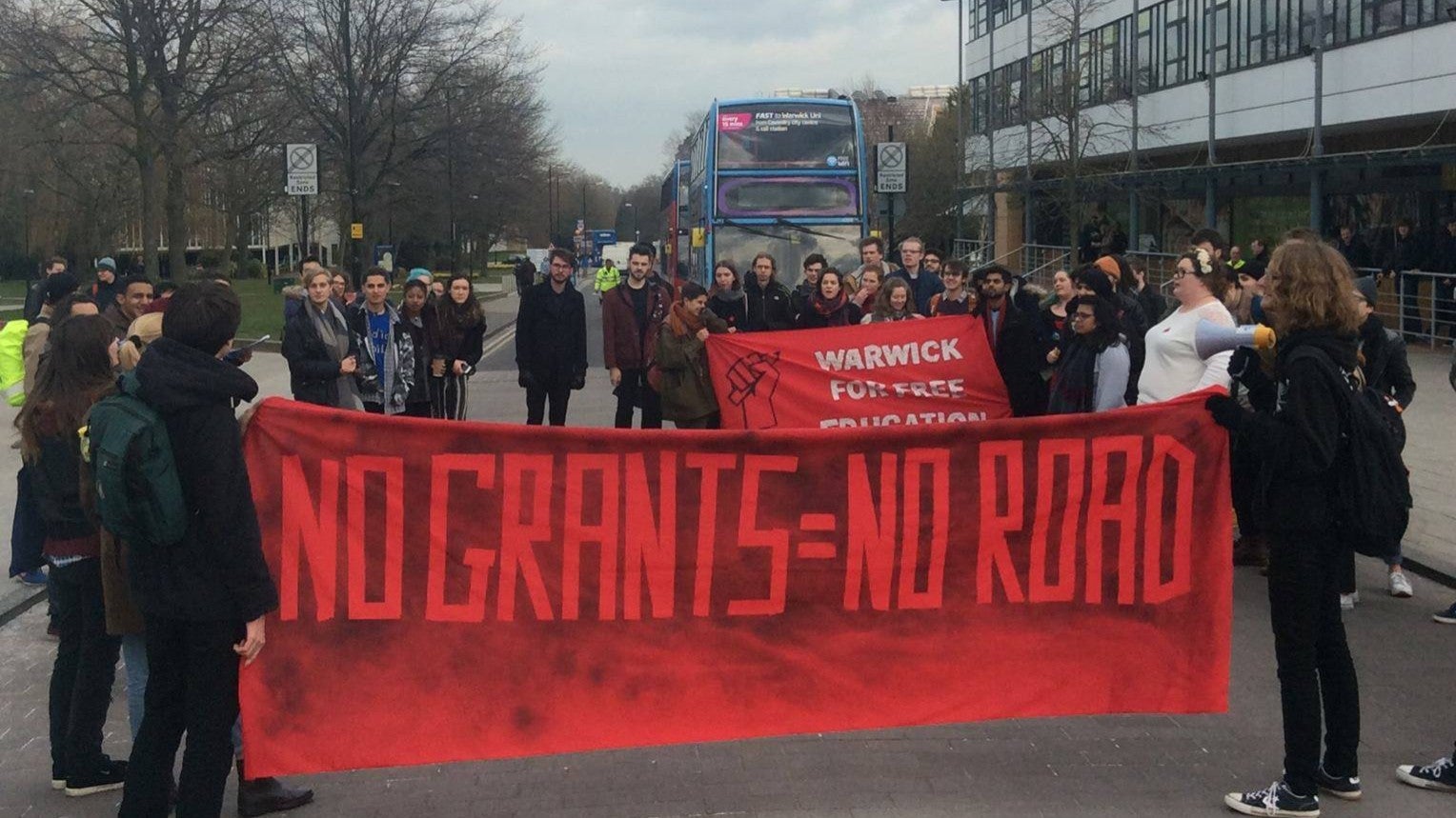 Demonstrators block University Road for half and hour during a day of heated protests against the rising cost of higher education in England