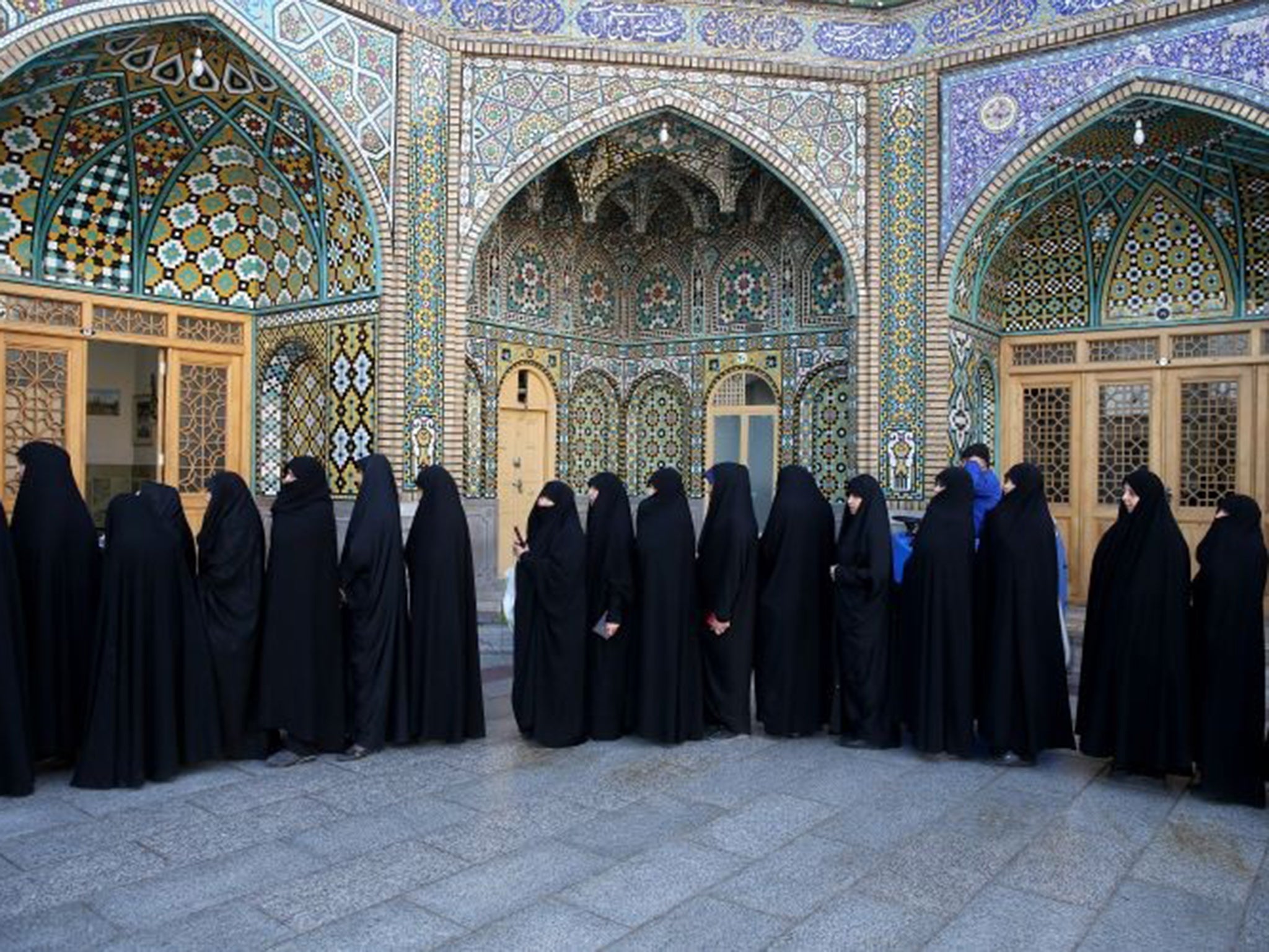 Iranian women queue to vote in parliamentary and Council of Experts elections yesterday at a polling station in Qom, 78 miles south of the capital Tehran.