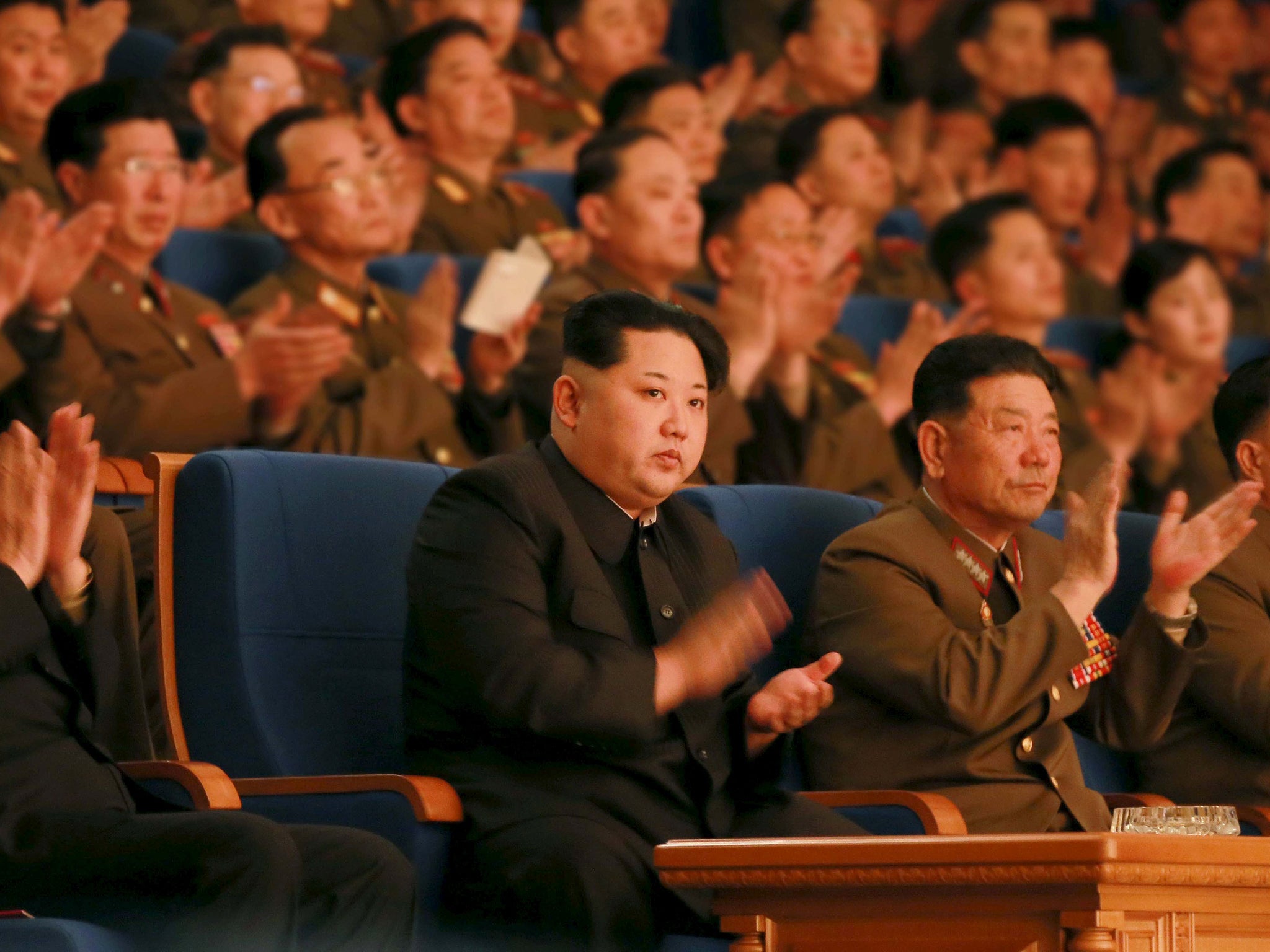 North Korean leader Kim Jong Un (C) applauds during a concert marking the 70th founding anniversary of the Korean People's Army (KPA) military band.